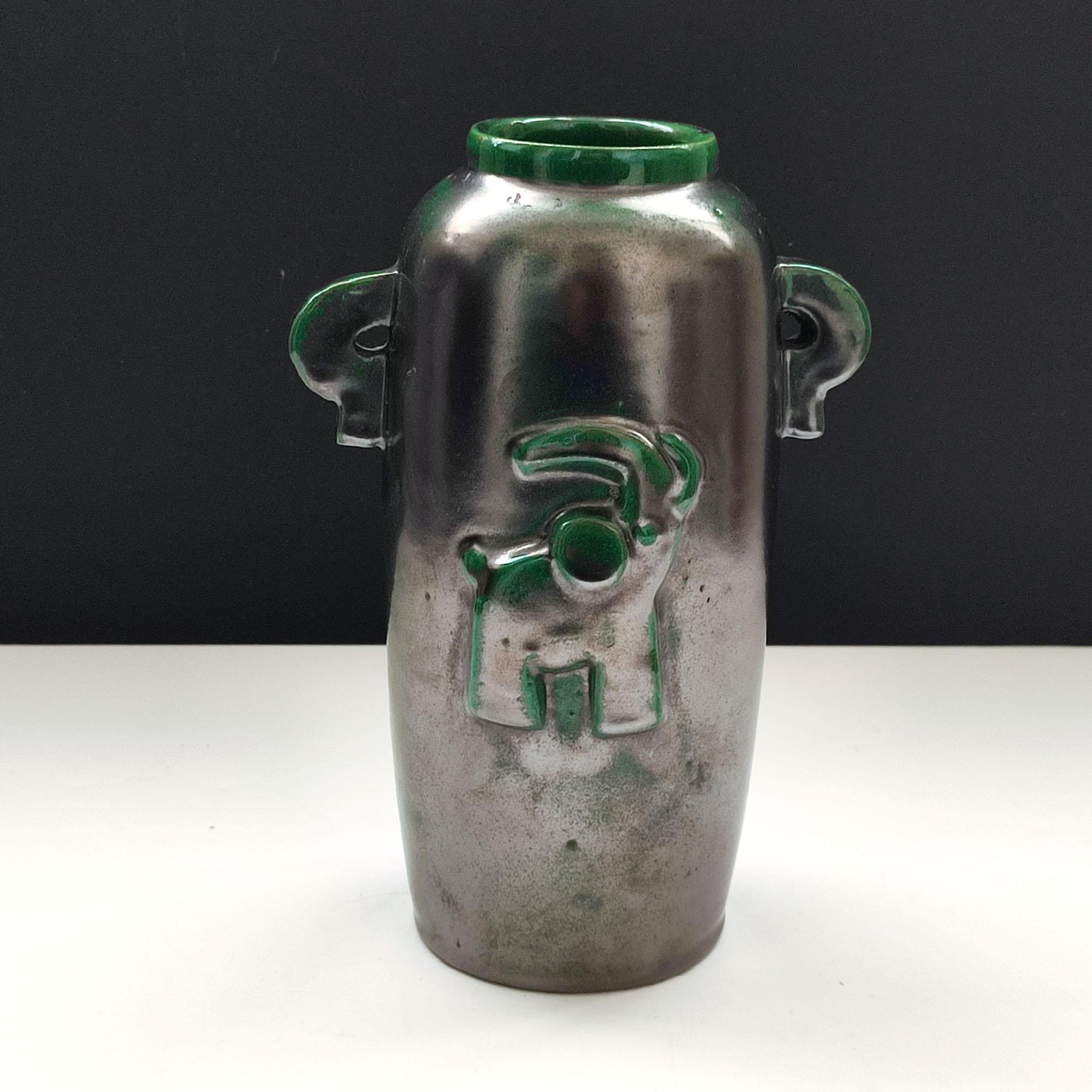 Un vase en faïence émaillée à l'éclat vert et noir, conçu par Einar Luterkort pour Motala Lervarufabrik dans les années 1930. Design Art Déco épuré, avec un éléphant stylisé en relief sur le devant. Deux petites poignées décoratives sur les