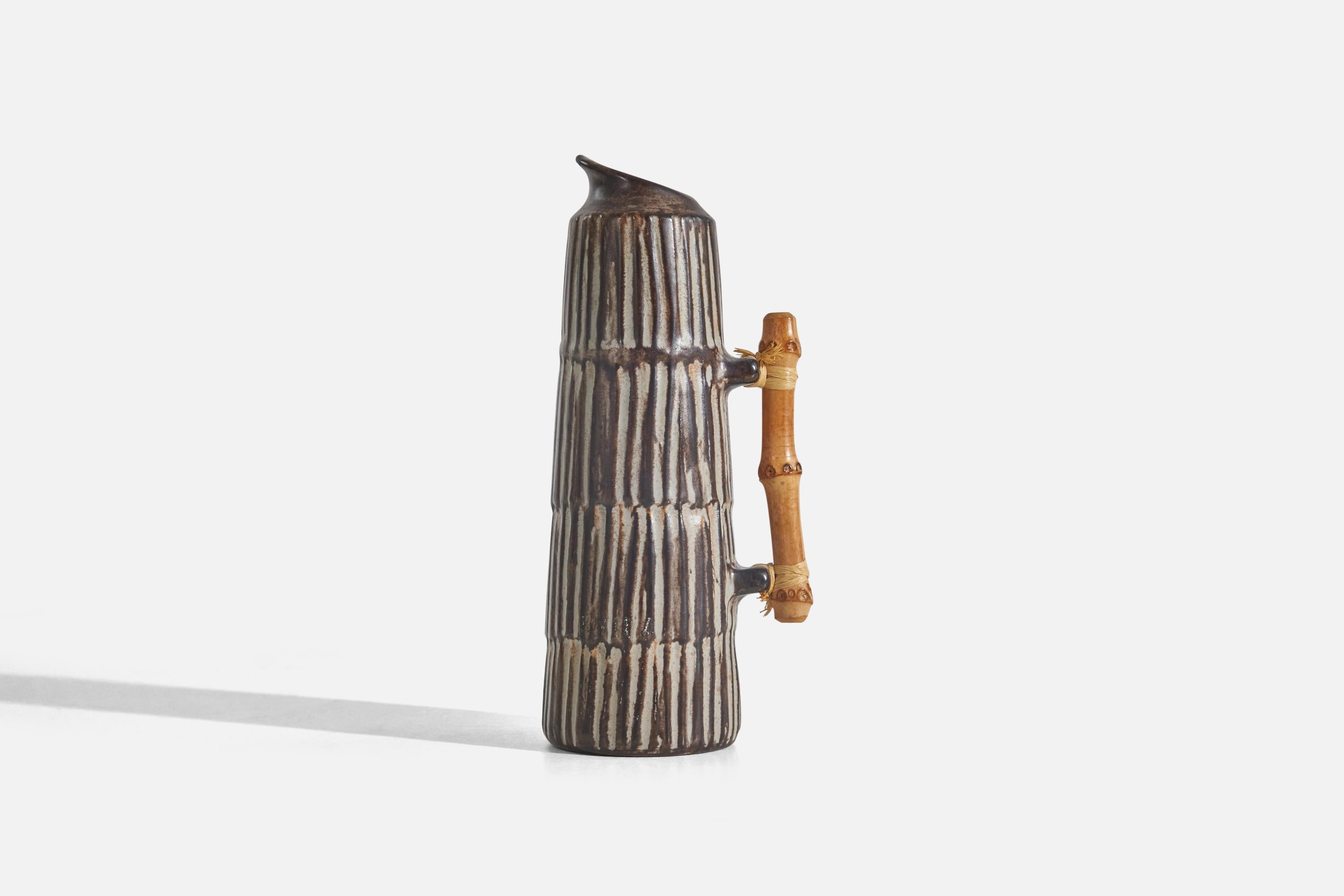 A brown and white-glazed stoneware and bamboo pitcher designed by Einer Hellerøe and produced by BR Keramik, Denmark, c. 1960s.