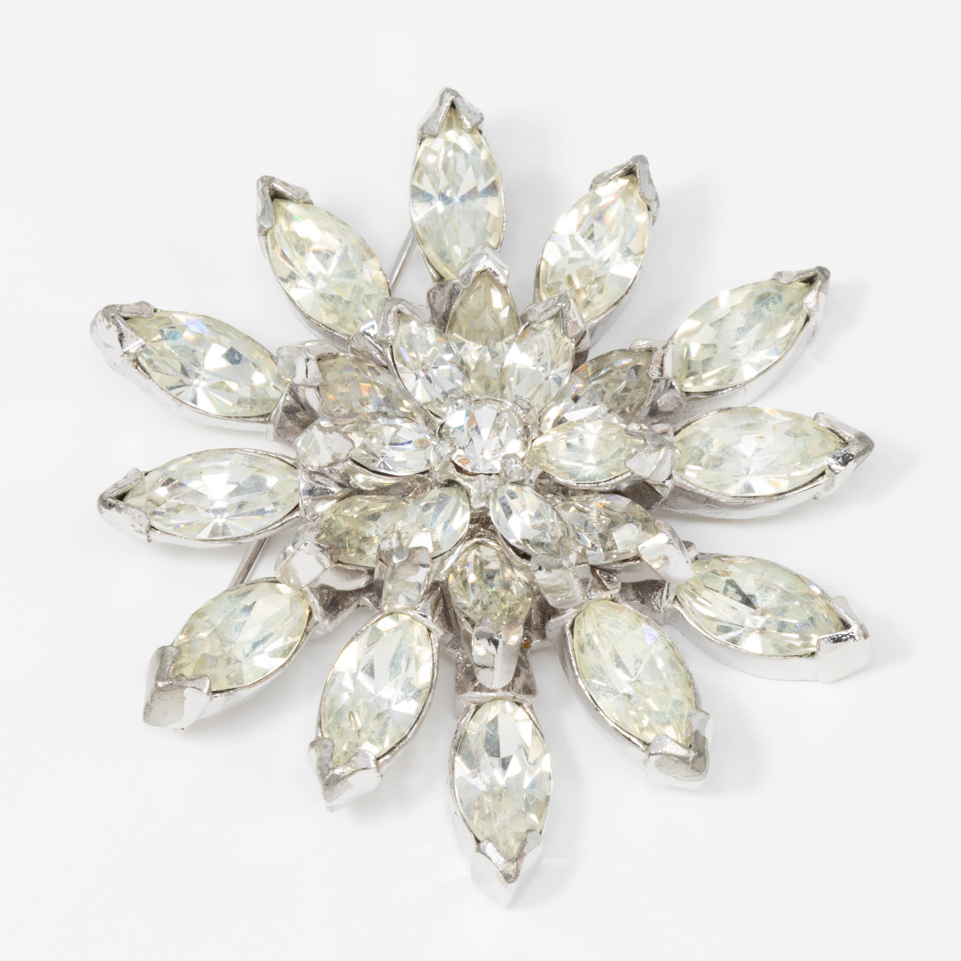 A sparkling pointed petal flower pin brooch from the 1940s Eisenberg Original collection. This glittering accessory features prong-set clear crystals on a silvertone setting, fastened with a pin clasp.

Tags, Marks, Hallmarks: Eisenberg Original