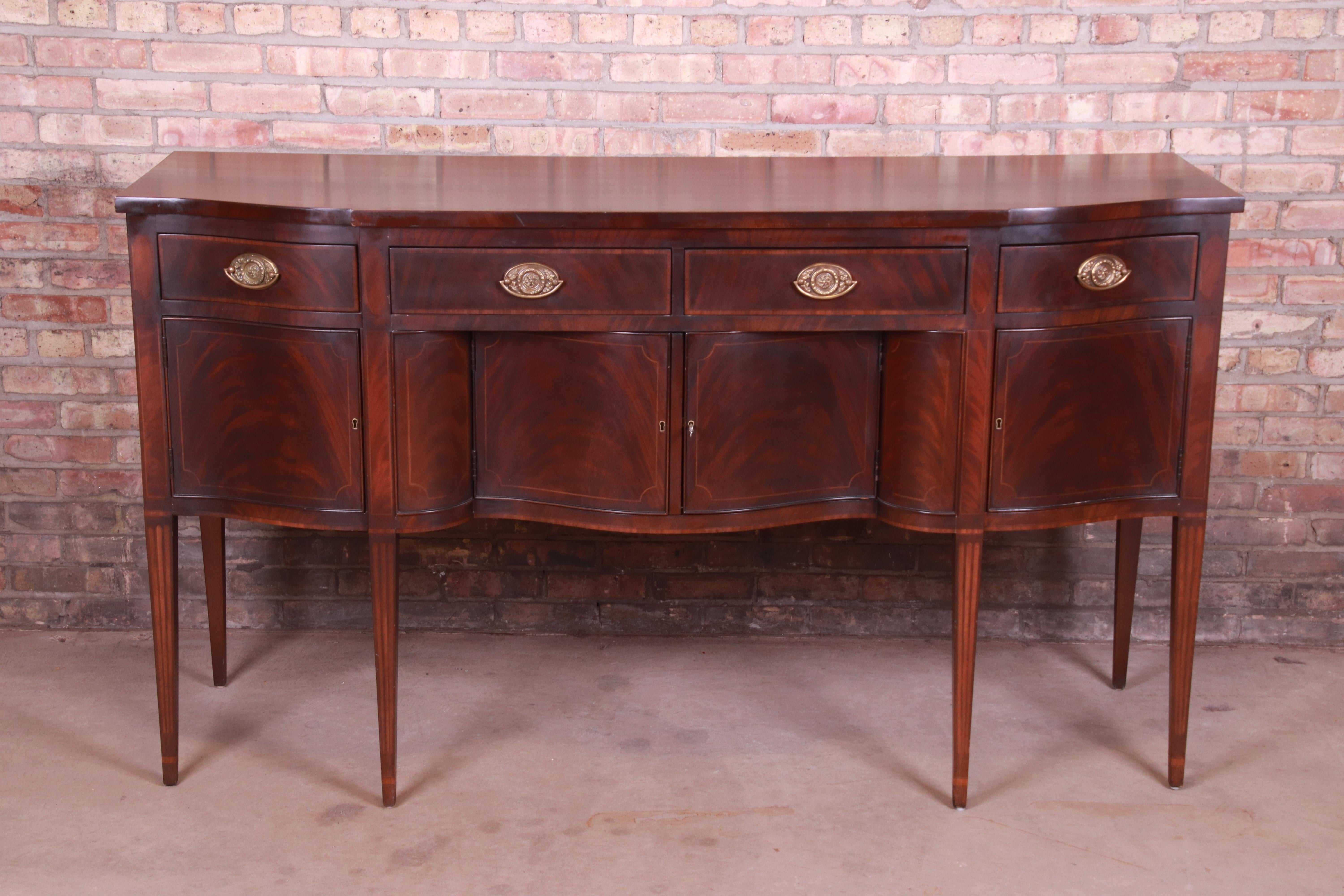 A gorgeous Hepplewhite style sideboard or credenza

By E.J. Victor

USA, late 20th century

Book-matched flame mahogany, with original brass hardware.

Measures: 70