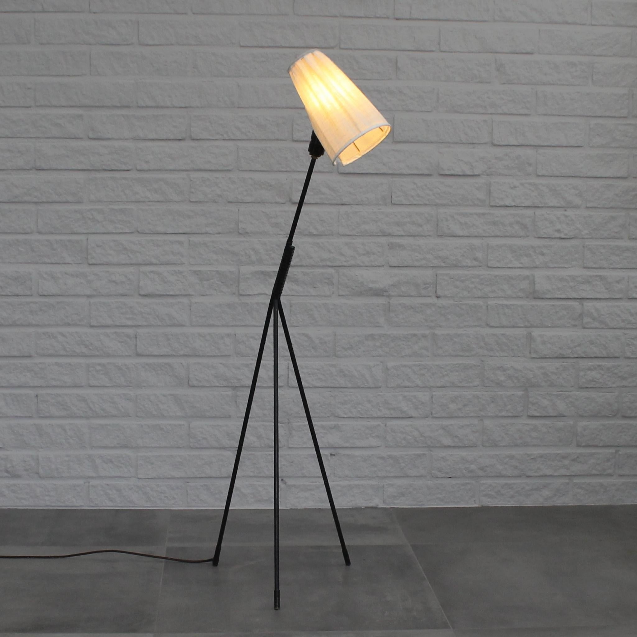 Swedish mid-century floor lamp, model 2612, designed by Eje Ahlgren for LUCO Armaturfabrik in Gothenburg. It features a tripod frame made from steel, partially adorned with a plastic stripe. The lamp shade is adjustable and covered in off-white