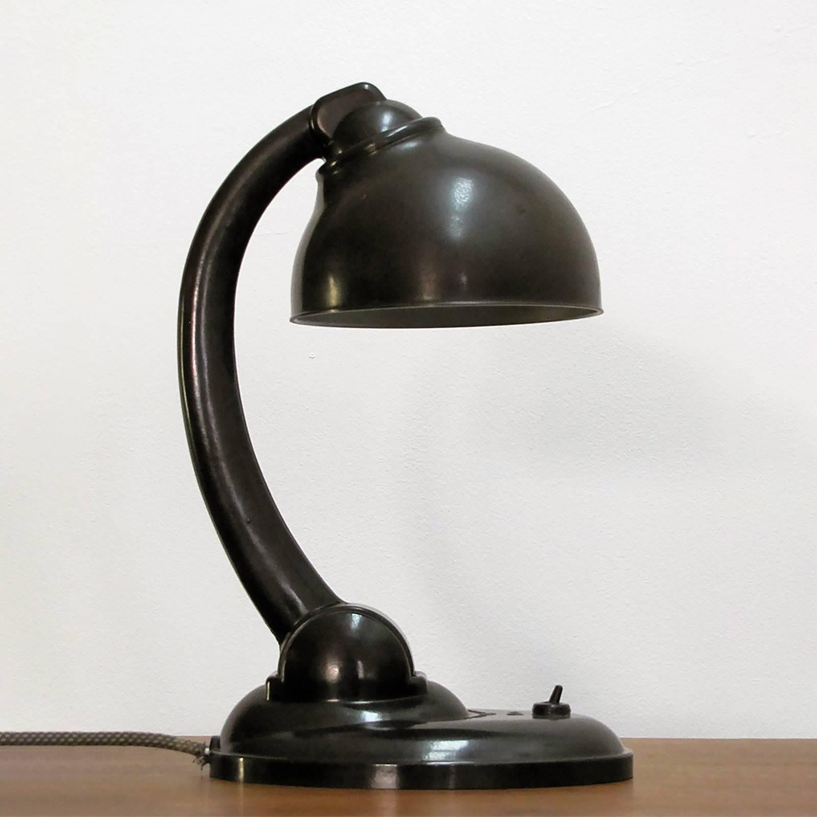 Wonderful bakelite table lamp by E.K.Cole for ESC, the shade is mounted to a shoulder joint and can be adjusted in all directions, the curved swivel arm rests on a streamlined base with an individual on/off switch, newly wired with textile cable and