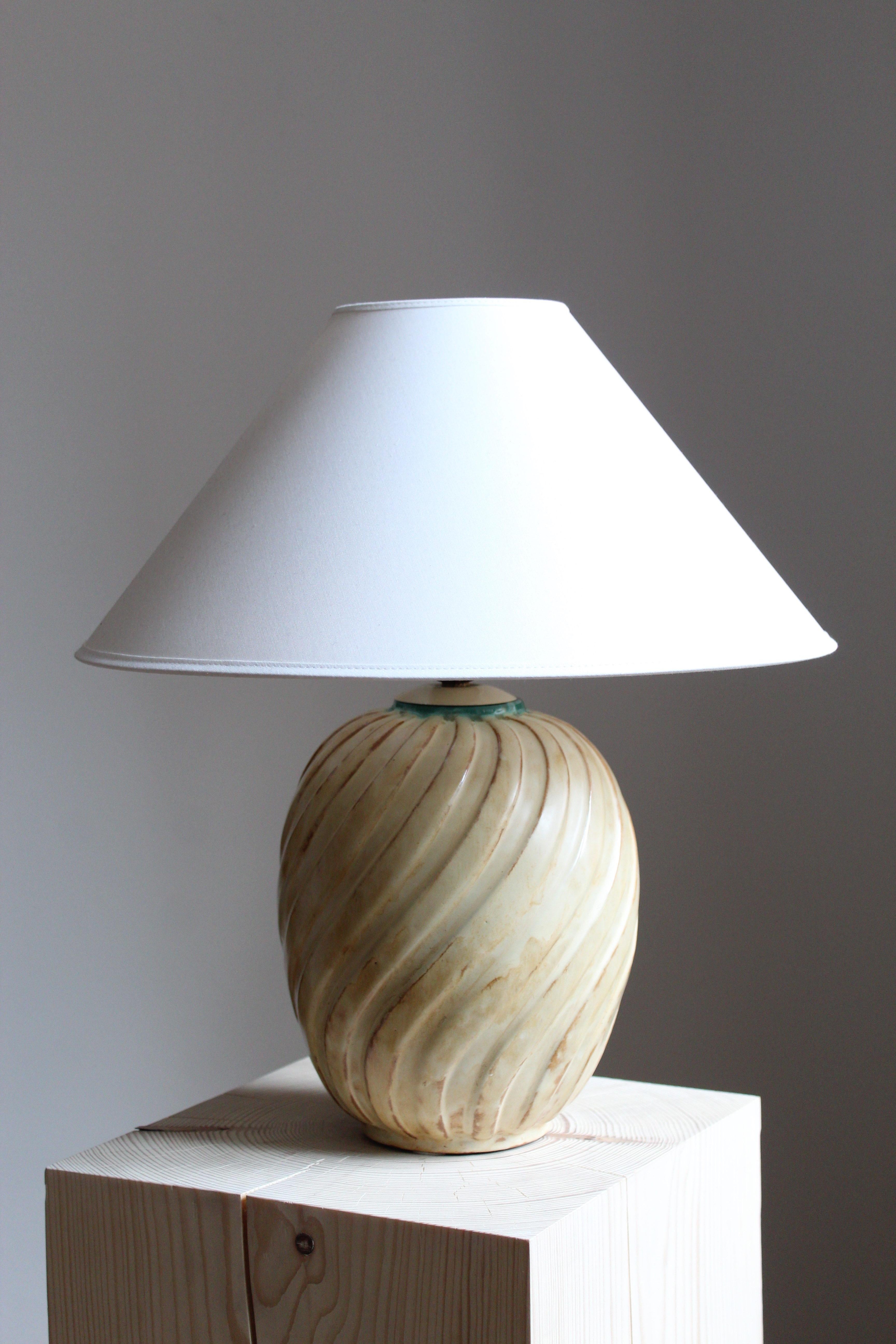 A sizable table lamp by iconic Swedish ceramic firm Ekeby. In glazed stoneware. Marked.

Sold without lampshade, stated dimensions excluding lampshade.

Glaze features brown-beige colors.

Other designers of the period include Axel Salto, Carl Harry