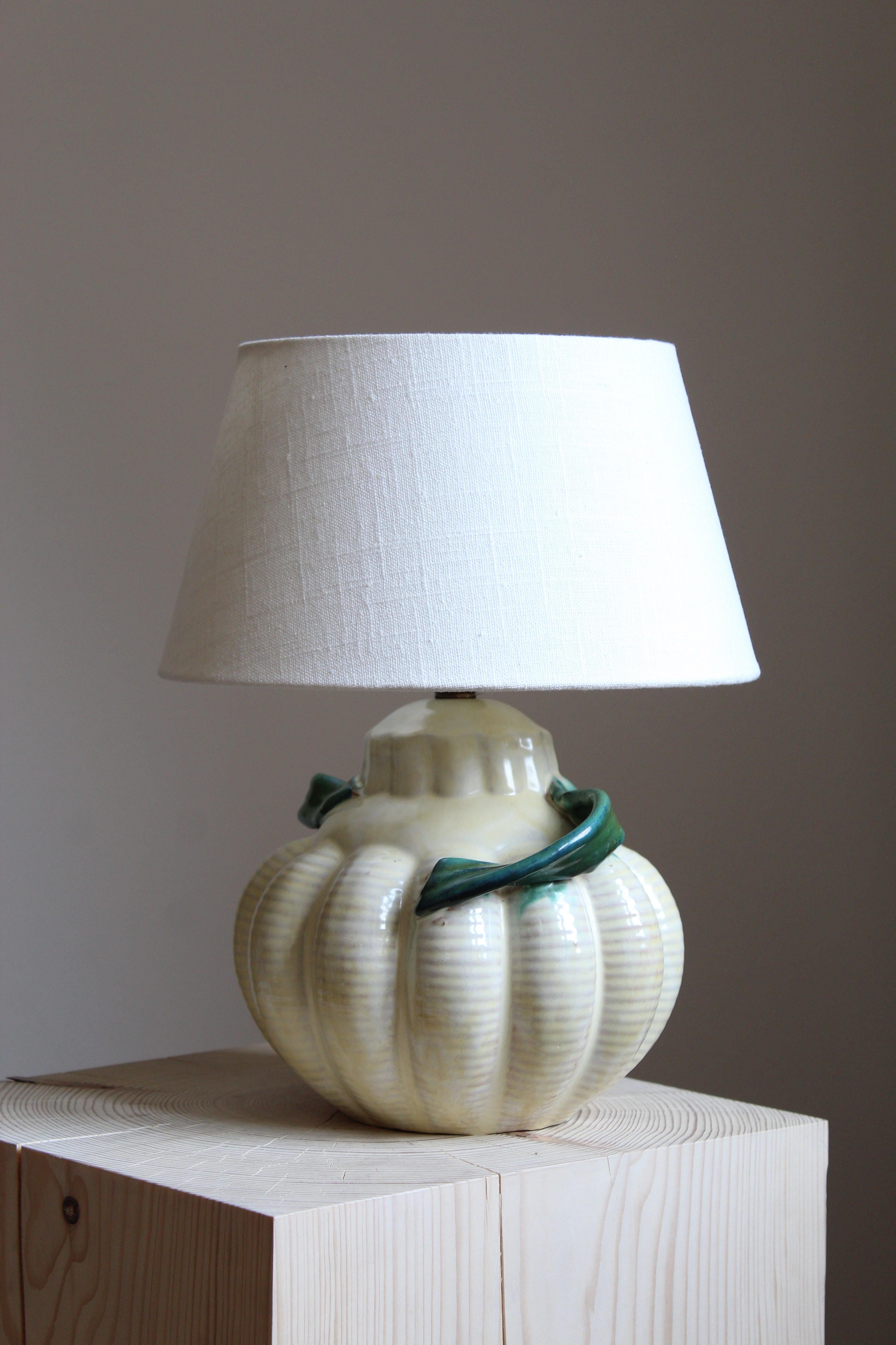 A table lamp by iconic Swedish ceramic firm Ekeby. In glazed and hand-painted ceramic. Marked.

Sold without lampshade. Stated dimensions exclude lampshade.

Glaze features white-green colors.

Other designers of the period include Axel Salto, Carl