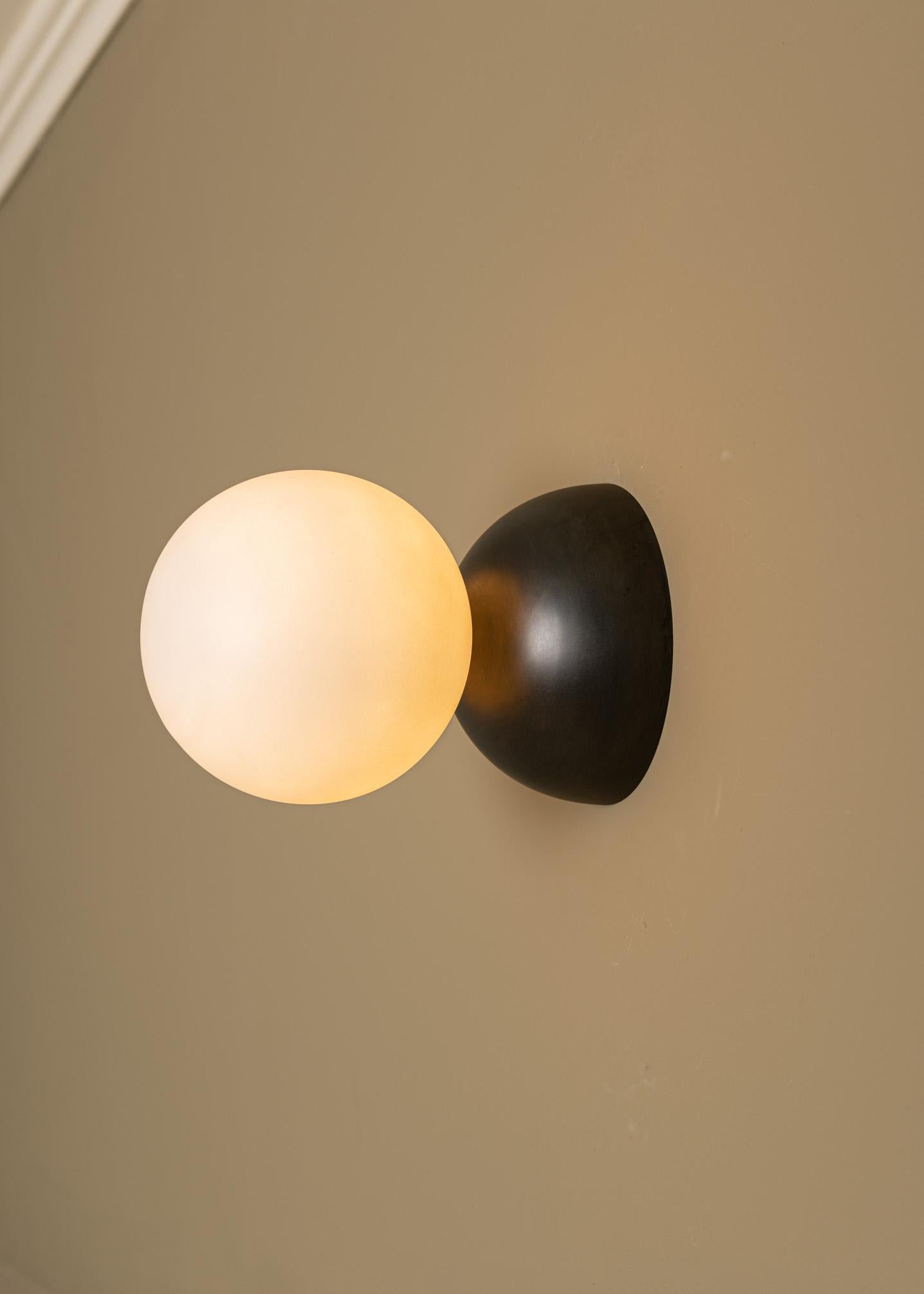 Eklipso Blackened Steel Wall Sconce by Simone & Marcel
Dimensions: D 19,5 x W 14 x H 14 cm.
Materials: Blackened steel and glass.

Available in different marble, brass, steel and alabaster options and finishes. Custom options available on request.