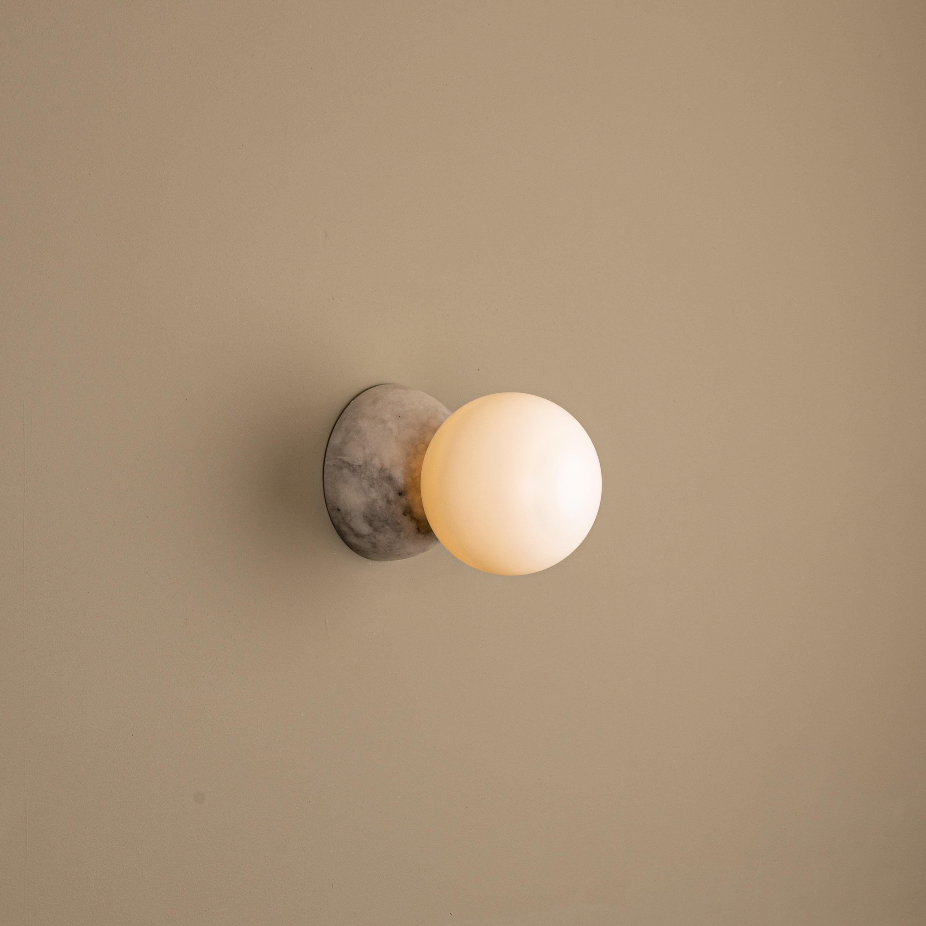 Eklipso Tobacco Alabaster Wall Sconce by Simone & Marcel
Dimensions: D 19,5 x W 14 x H 14 cm.
Materials: Tobacco alabaster and glass.

Available in different marble, brass, steel and alabaster options and finishes. Custom options available on