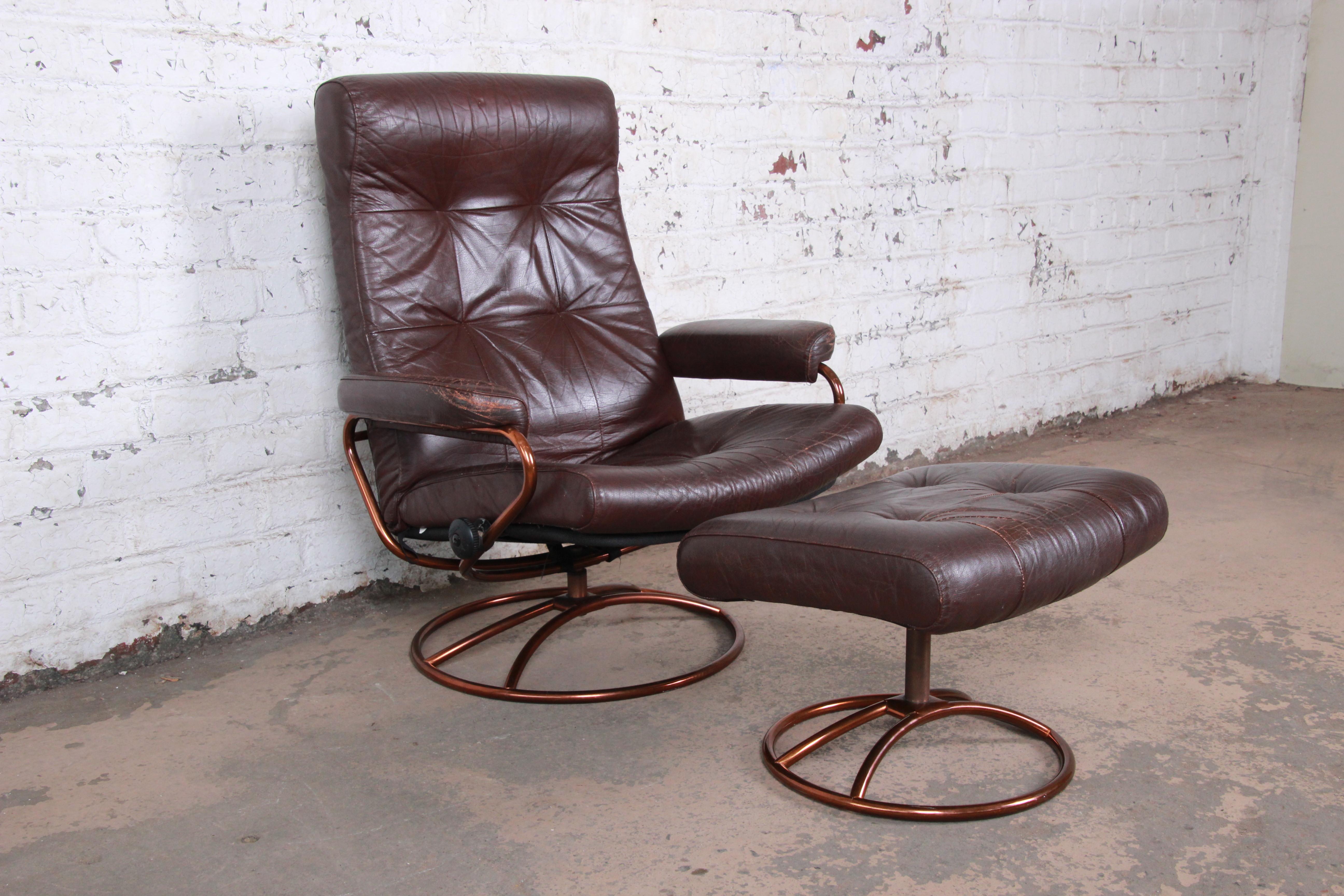 A beautiful vintage Ekornes Stressless lounge chair and ottoman in brown leather. The chair features soft brown leather upholstery and sleek Scandinavian design. The leather is worn in with a nice patina. Both the chair and ottoman have swivelling