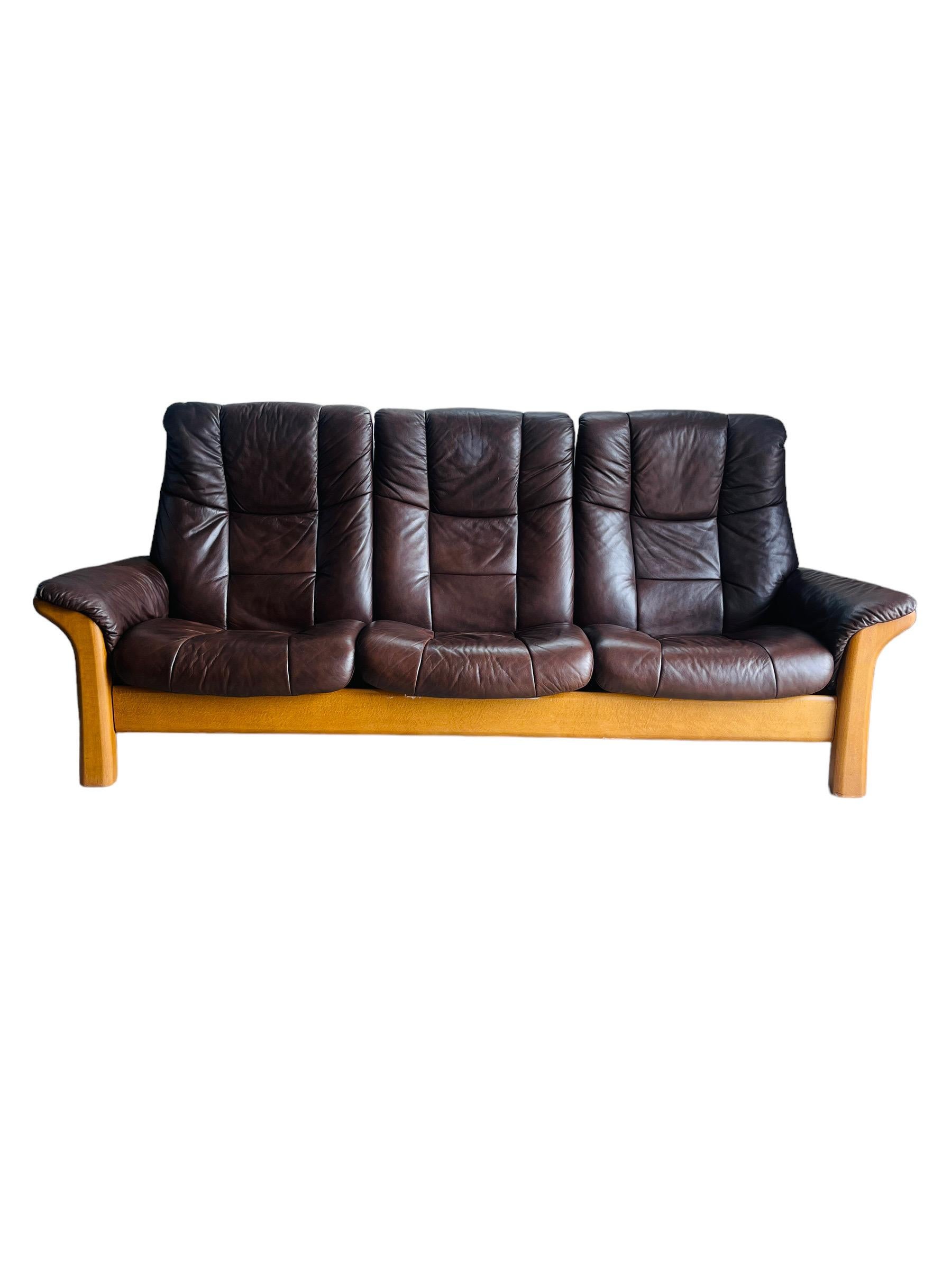 Introducing the Ekornes Stressless Sofa, the epitome of comfort, style, and craftsmanship. With its elegant brown leather upholstery and sturdy solid wood frame, this sofa adds a touch of sophistication to any living space. 

Indulge yourself in