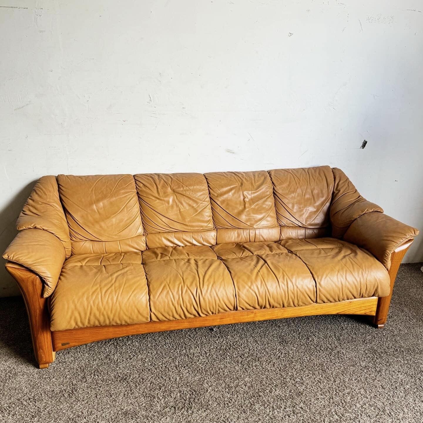 Enhance your living space with the Ekornes Stressless Leather Sofa, featuring luxurious tan leather upholstery. The plush cushions and ergonomic design provide exceptional support, while the sturdy wooden base adds modern stability. Perfect for both
