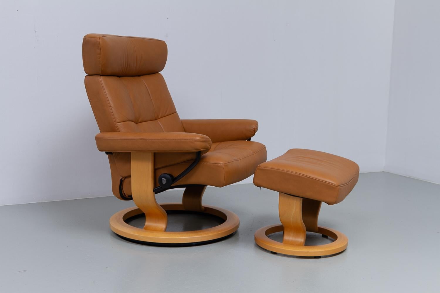 Ekornes Stressless Reclining Lounge Chair and Ottoman, 2000s.

Scandinavian Mid-Century Modern recliner with footstool produced by Ekornes Norway Model Stressless.

Very soft medium brown cognac colored leather. Wide comfortable reclining seat,
