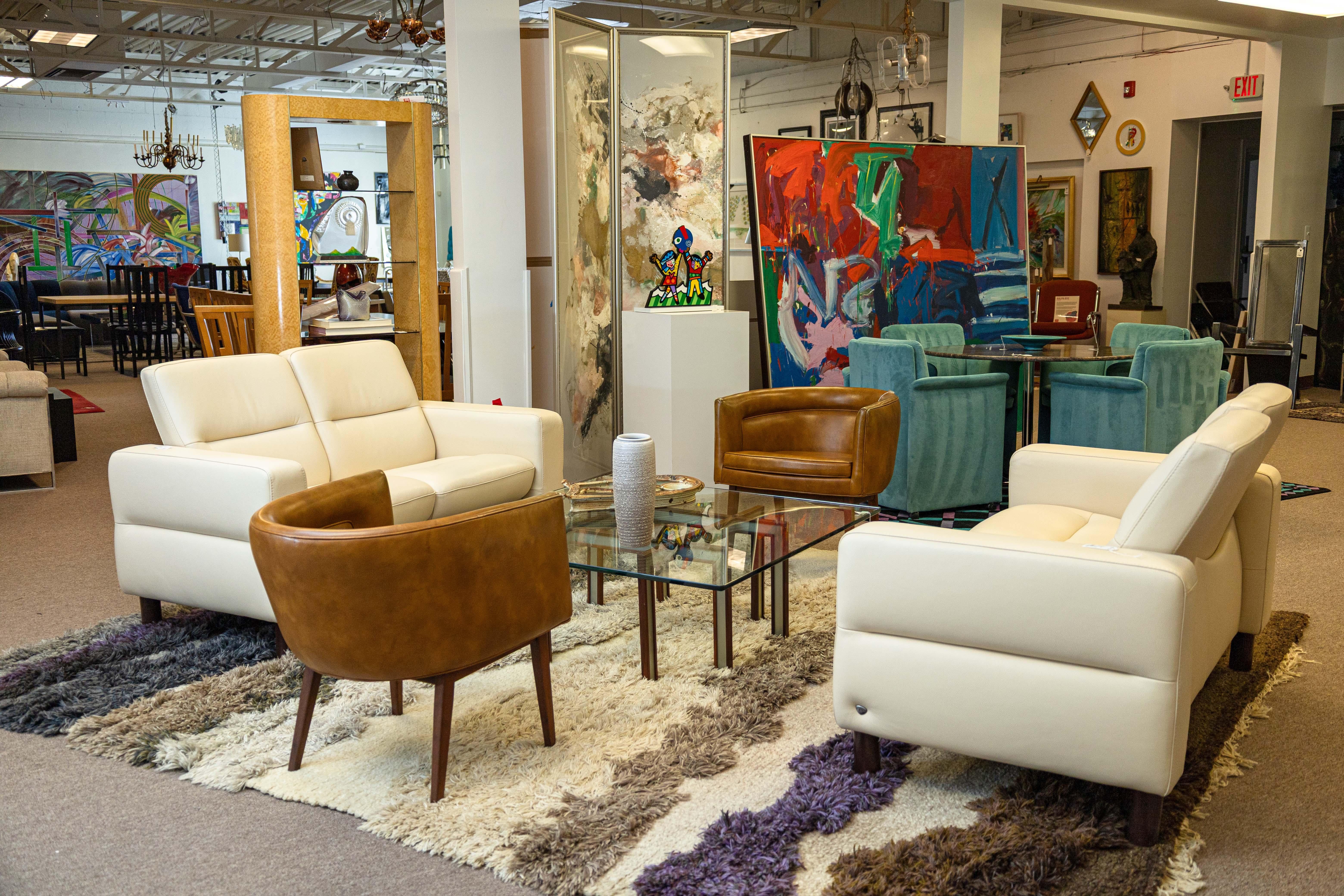 An Ekornes Stressless Wave lowback loveseat. This lovely modern Danish sofa features very high quality materials and construction. This piece has a very sturdy wood and metal frame with a super clean cori vanilla leather outer upholstery. The cori