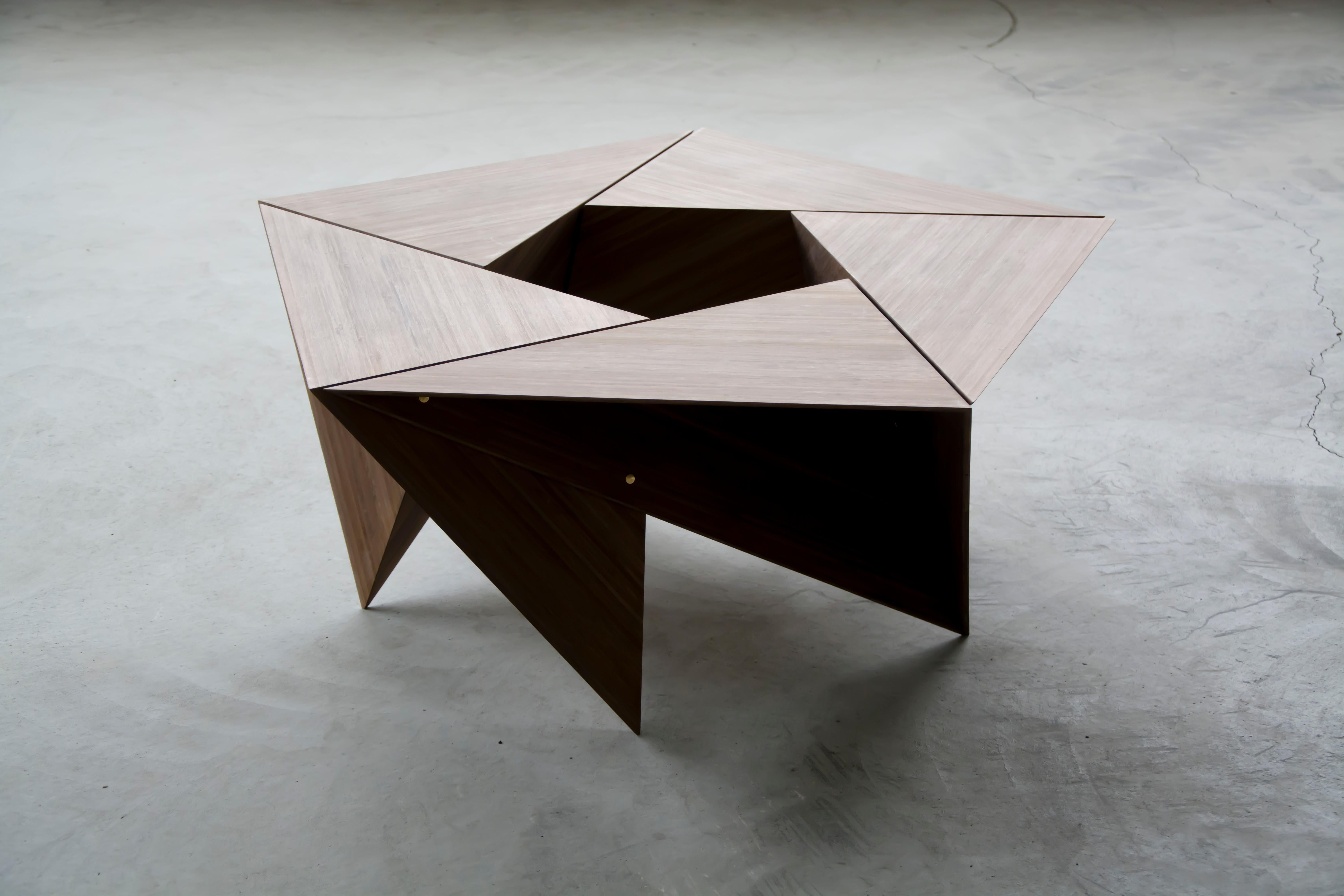 This pentagonal table is comprised of 5 identical open faced tetrahedron. Held together with brass barrel bolts, the unit can be disassembled and nested for compact shipping.

Images here show a grey stained bamboo plywood, and a birch plywood.