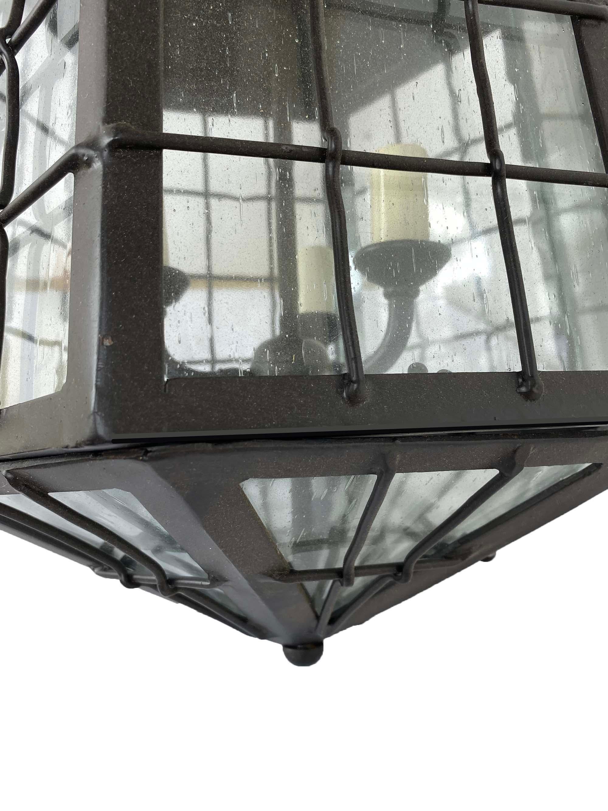 This wrought iron lantern was inspired by a Spanish Colonial house in Santa Barbara. It is also in the style of ships lanterns on the 19th century. The intricate woven cage and tapered shape make it quite interesting. This is a new lantern that can