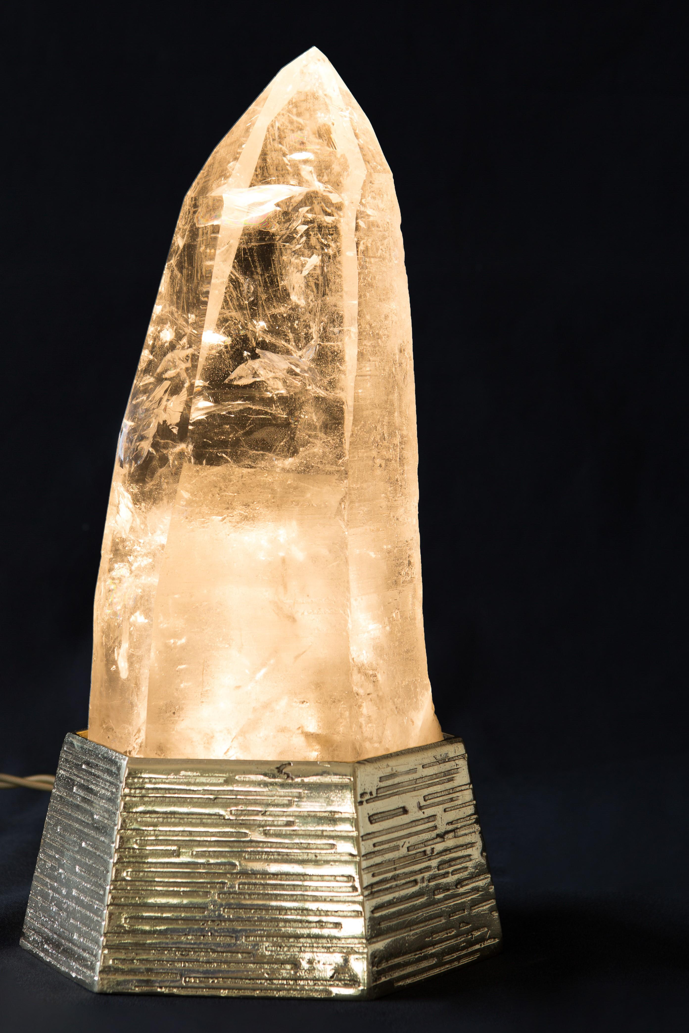 Ela natural quartz table lamp by Demian Quincke
Dimensions: Diameter 13 x height 34 cm
Materials: Casted bronze base and extra natural quartz point

5W, GU-10 LED light inside, Bi-Volt 110/220 V
4.8 kg natural rock crystal point, 2 kg base, total