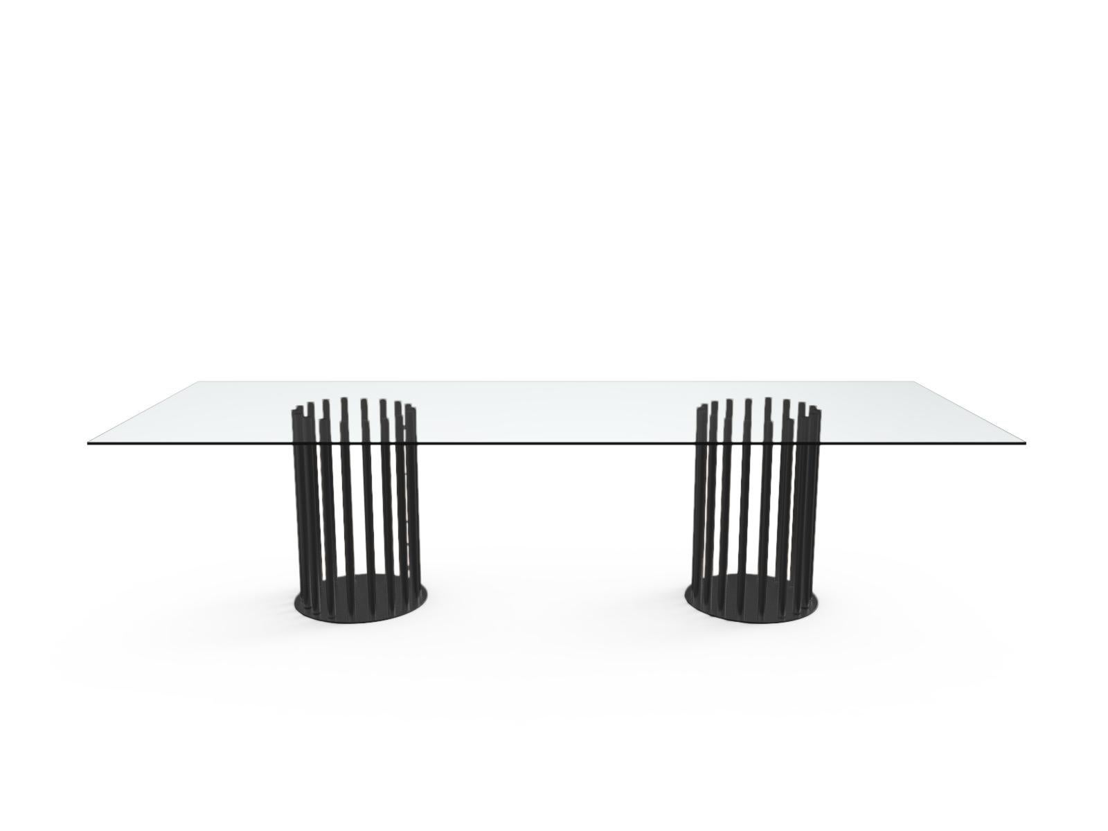 Rectangular dinner tables with extra light tempered glass top with satinated fillet in different sizes, supported by a series of light and slim metal legs, available in the following finishes in RAL colors or brass, dark bronze, satin-finish black.