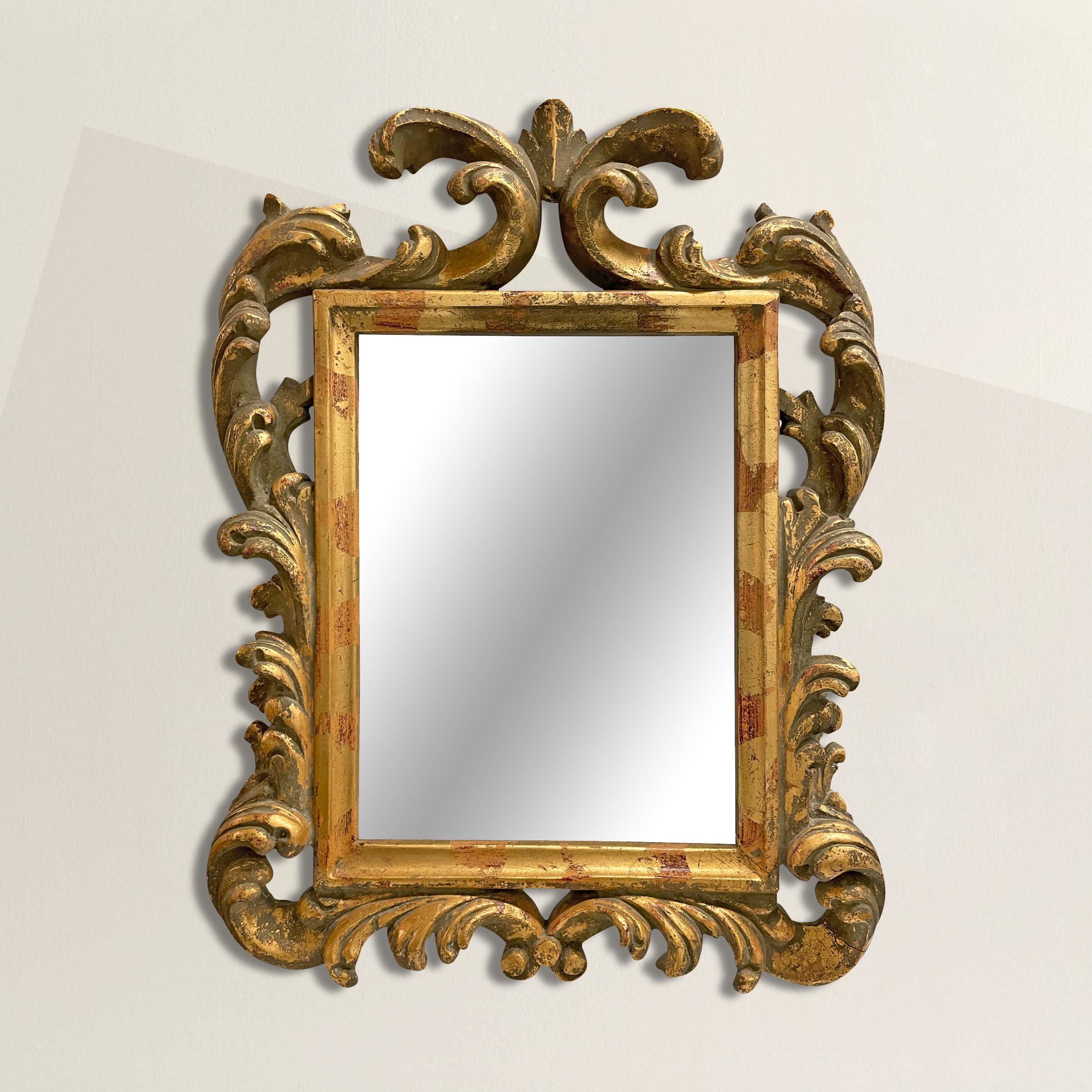A wonderfully elaborate Baroque-style framed mirror with a gilt wood frame with applied painted and gilt composition scrolling foliate forms. Perfect for your powder room, entryway, or any other spot you need a little extra sparkle!