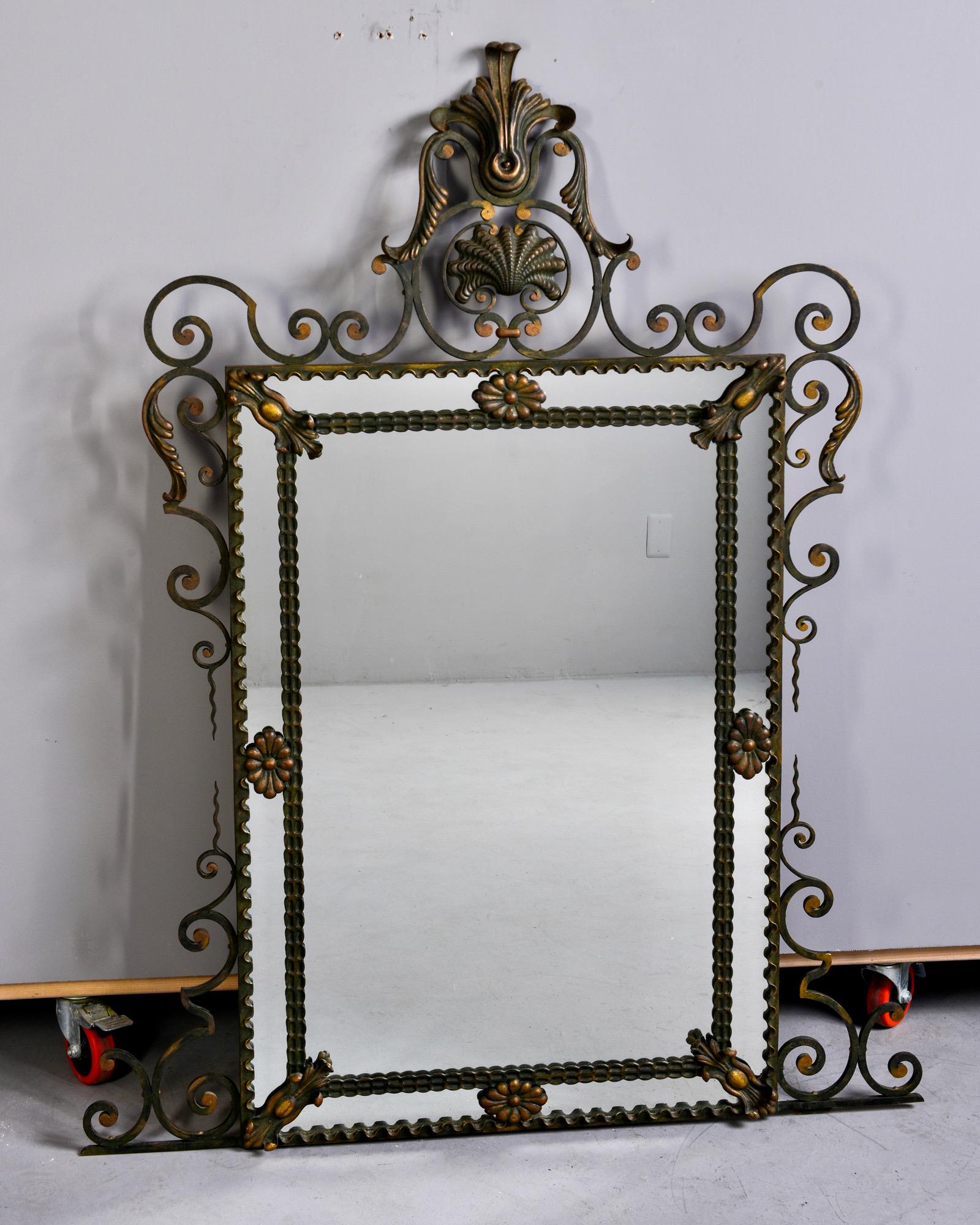 Found in France, this circa 1900s mirror features a fancy iron frame with tall crest and scrolled details at corners. Original green painted finish with gilded details. Marked by maker, Clavell on lower right hand side of frame. 

Very good