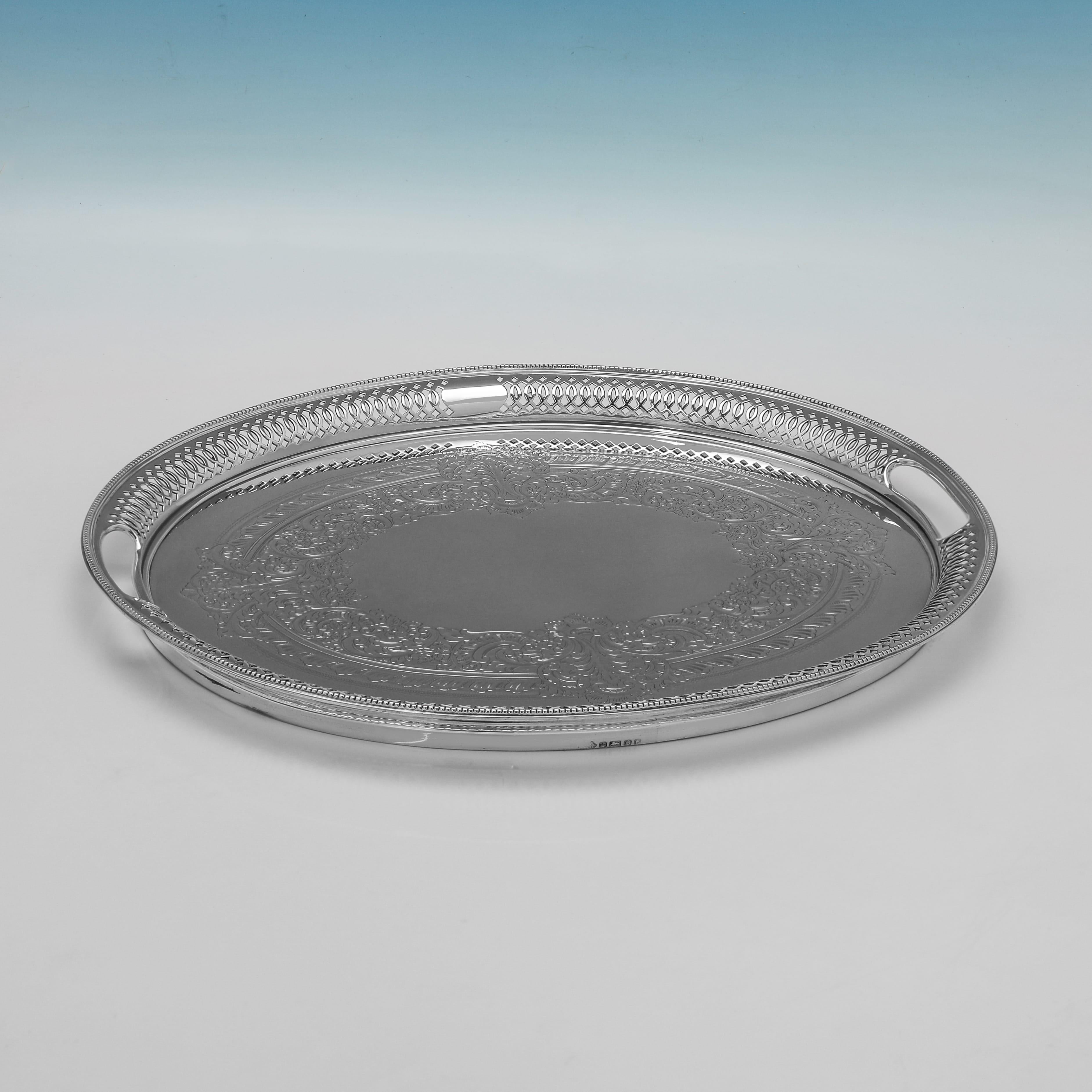 Hallmarked in Sheffield in 1897 by Martin 
Hall this elaborate Victorian antique sterling silver oval tray has a finely pierced gallery with an intricate interlocking design. The centre of the tray is decorated with fine foliate scroll