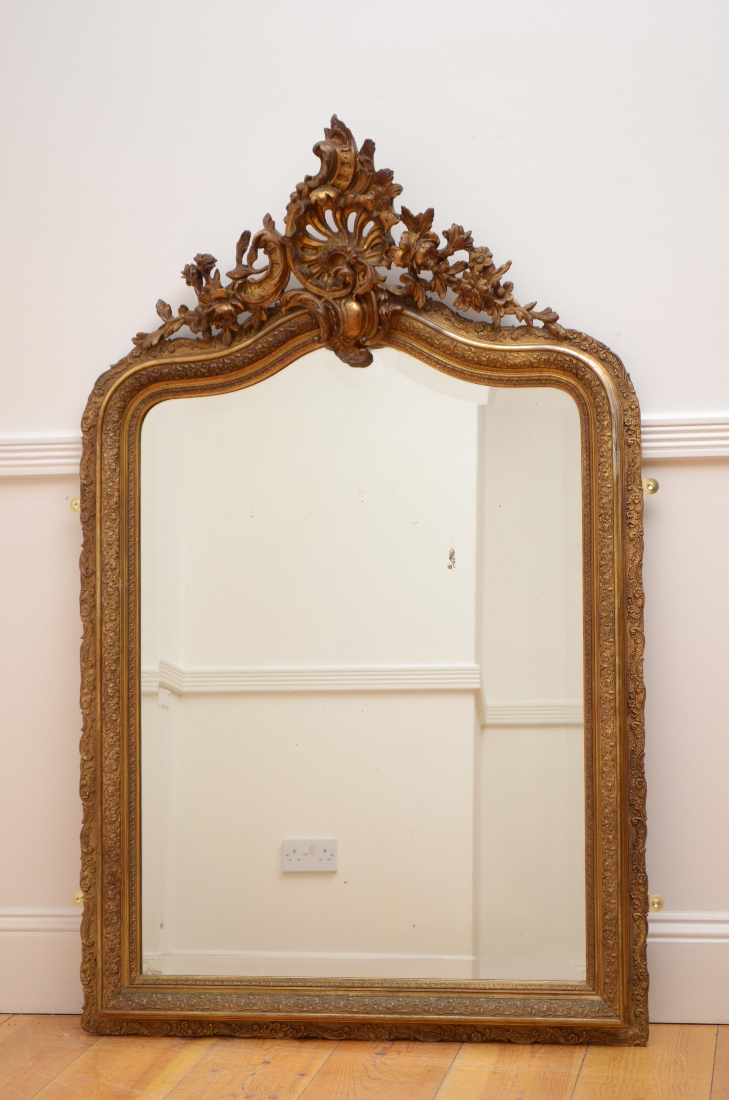 K0445 stunning antique French wall mirror with original bevelled edge glass with some foxing in beautifully carved and very elaborate gold leaf frame with exquisite centre crest to the top. This antique mirror retains its original glass, original