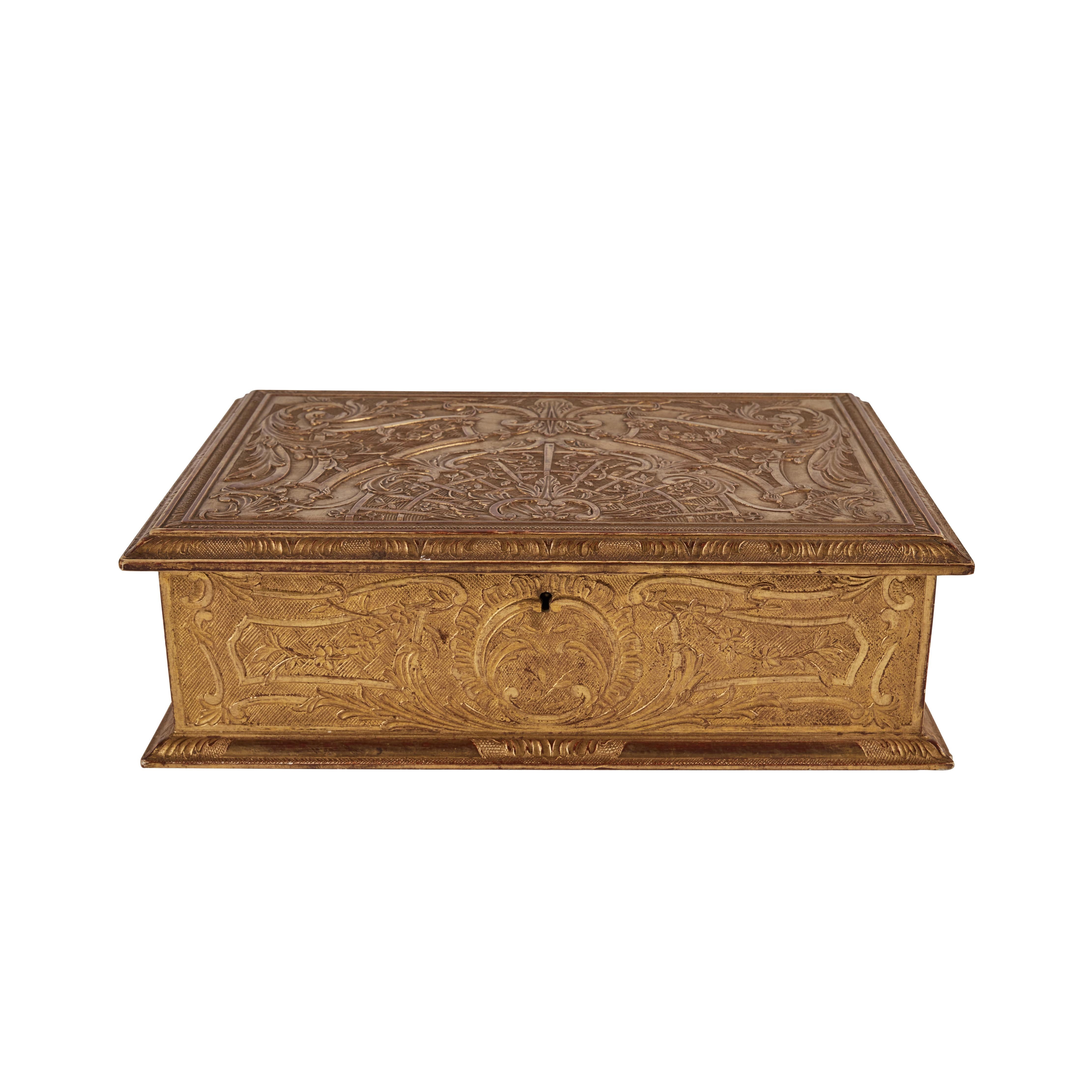 A richly hand-carved, hinged-top, gilt wood box. The whole embellished in scrolling foliate forms. Removable fitted tray.