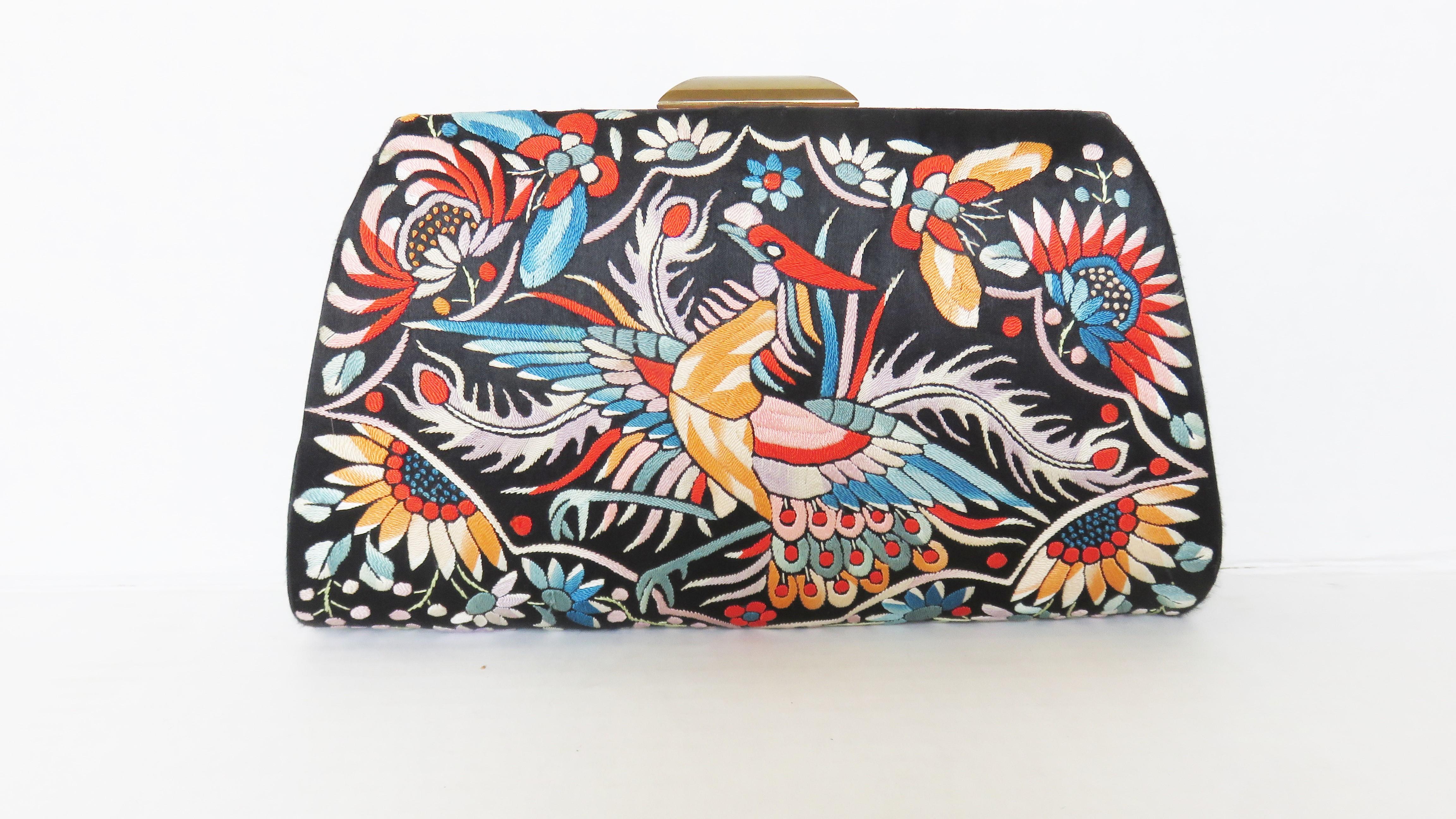 A gorgeous black silk clutch purse elaborately embroidered with a bird and flowers on the front and back.  it has a gold metal frame, top snap closure and is lined in black silk with 2 inner pockets

Width  9.50
