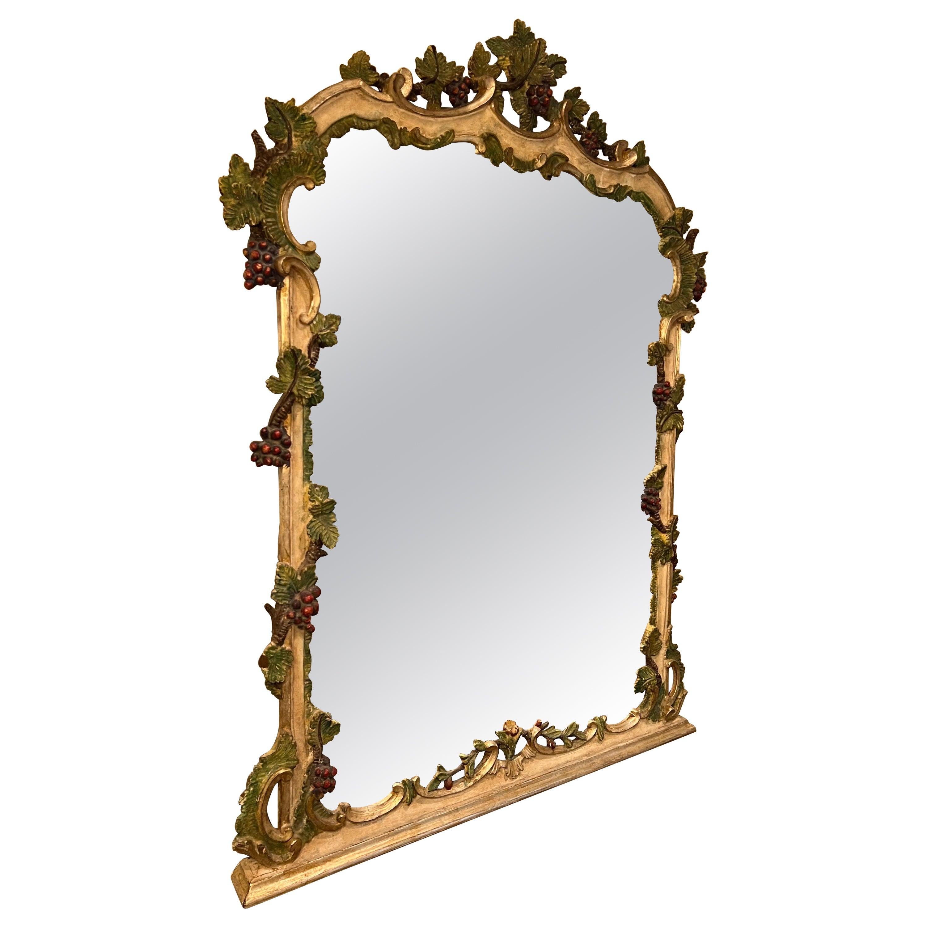 Elaborately Hand Carved French grape vine mirror. Amazing detail to this fine mirror. Intricately carved grapes and vines throughout. Polychromed surface in silver, green and berry color. Nice ample size. Use above a dresser or Mantel, front