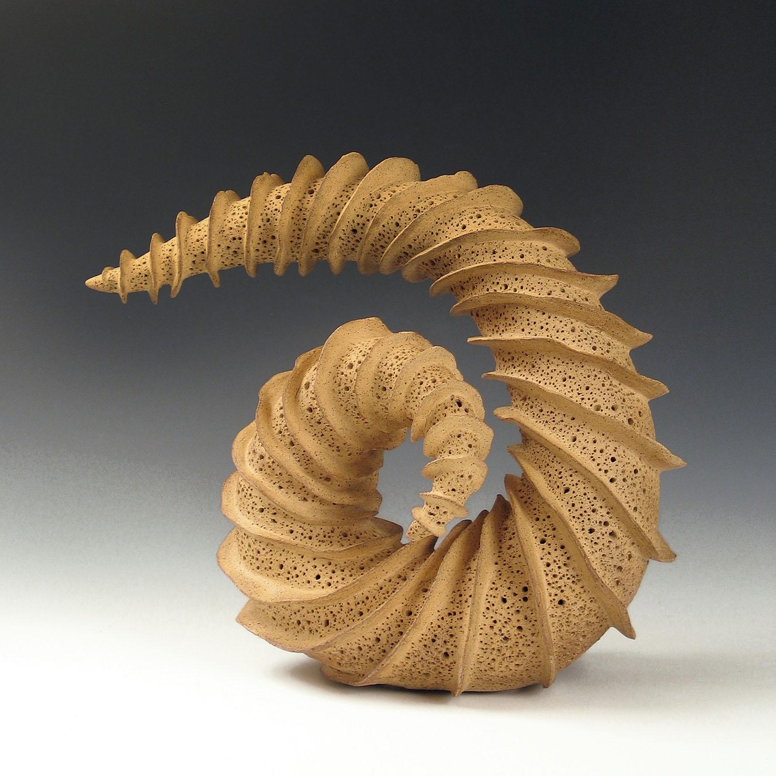  “Looking Back” radiates fins spiraling around a tapering coiled ceramic form. Always looking for new materials and methods, the artist has made sculpture in such diverse materials as wood, metal, concrete, encaustic and ceramic, maintaining a view