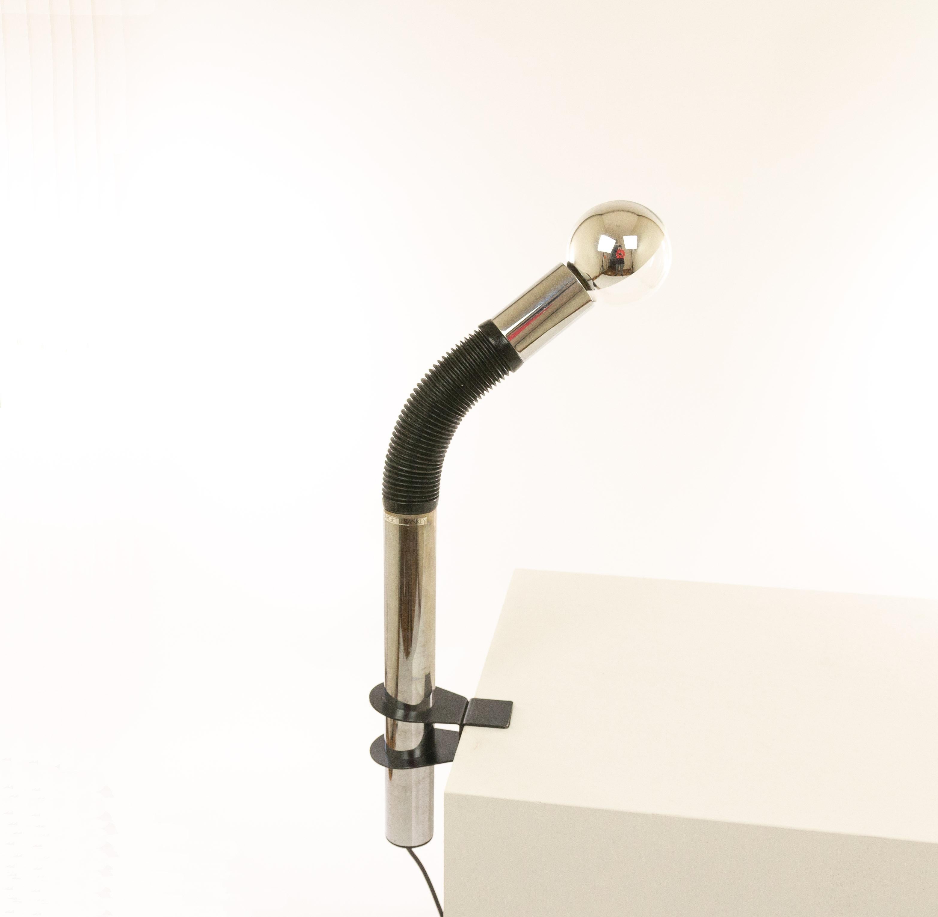 Elbow table lamp designed by E. Bellini and manufactured by Targetti Sankey in the 1970s.

The lamp is made of a chromed metal tube with a black rubber connection piece. The construction offers full flexibility. The black clamping element that