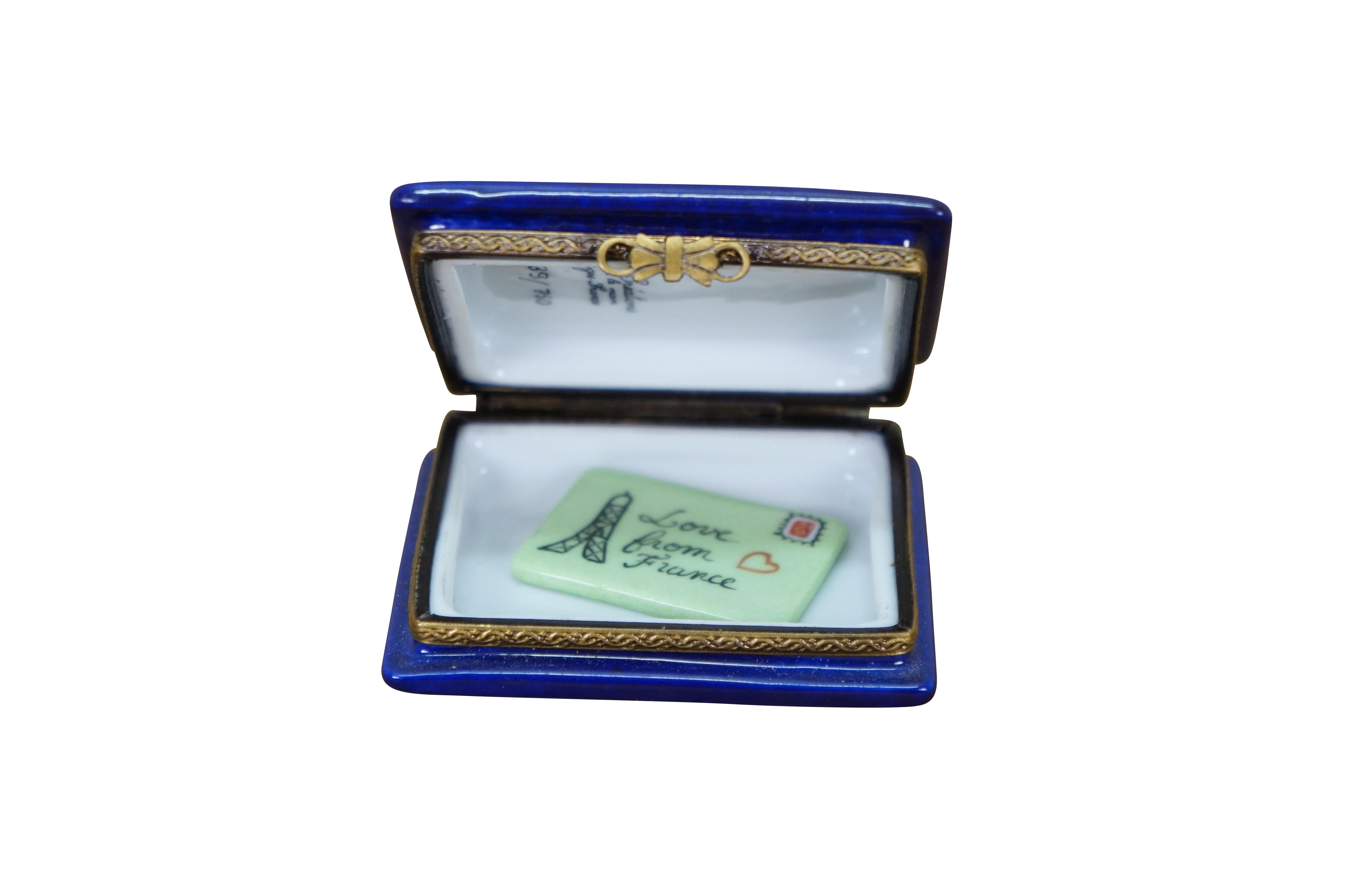 Late 20th century Elda Creations limited edition hand painted Limoges porcelain trinket / keepsake box in the shape of a blue and gold United States passport book with a miniature 