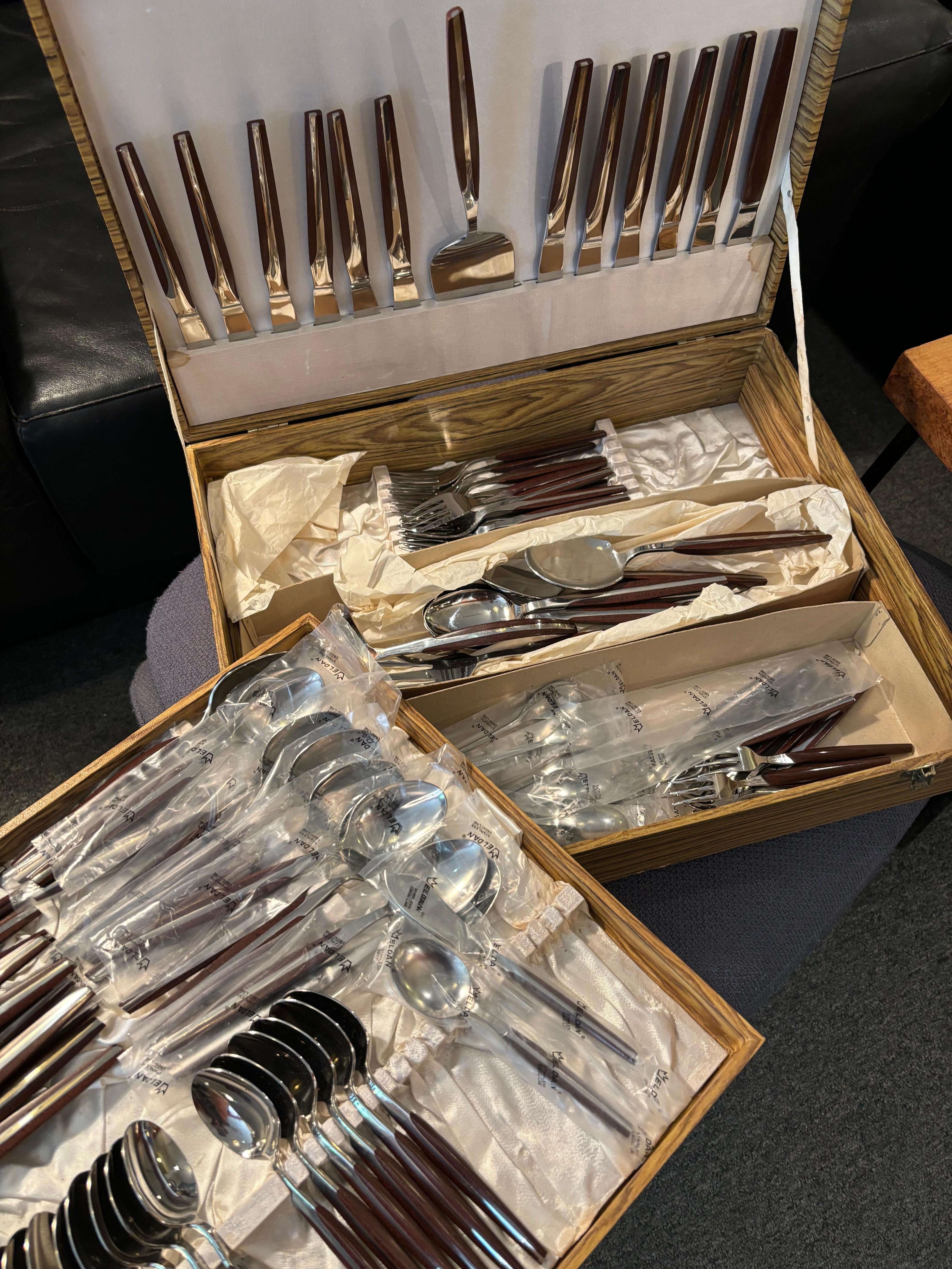 Massive 106 piece Set of Eldan Flatware.  Stainless Steel with a Melamine, or Bakelite type of molded handle.  This Set is brand new in the box!  Many pieces still have their plastic sleeves!  Never have I had such a clean Set!  Outer Box shows a