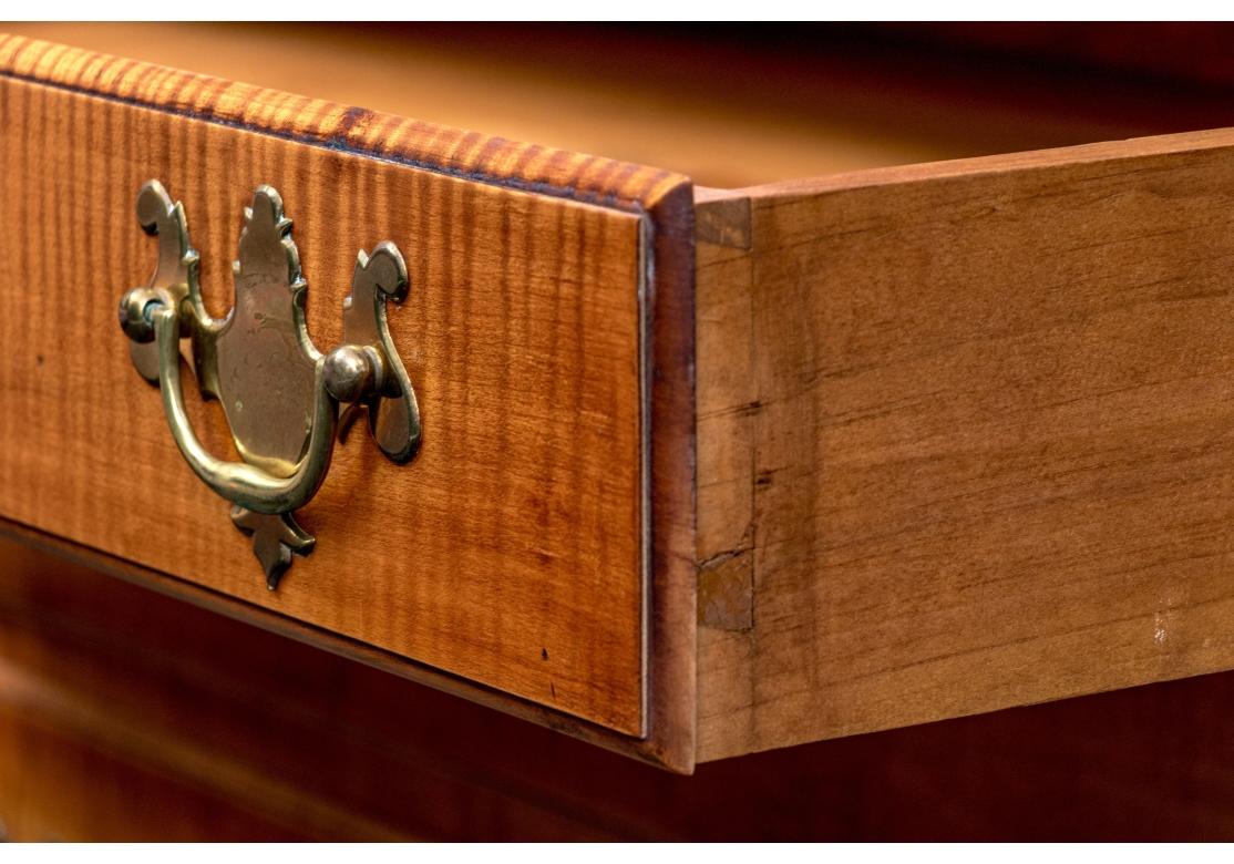 Mueble librería de dos piezas de arce tigre estilo Chippendale de Eldred Wheeler, con paneles de puerta en forma de lápida y fondo de escritorio inclinado. Armario con dos correderas para velas, parte superior moldeada y dos puertas. Las puertas se