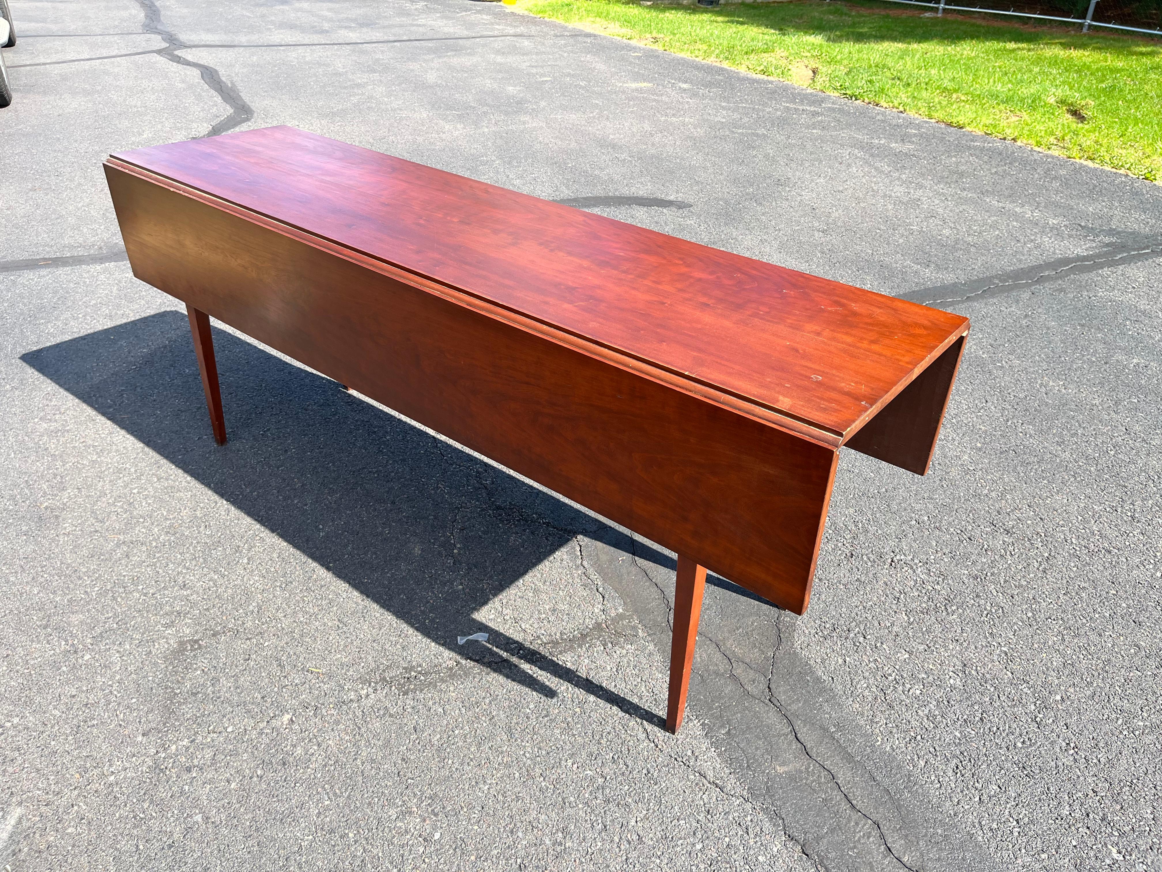 A wonderful cherrywood drop-leaf farm table in the Shaker manner by Eldred Wheeler, with hand-planed too and pegged construction. The table has a stamp and a paper label on the underside. Easily seats 8-10 people.
