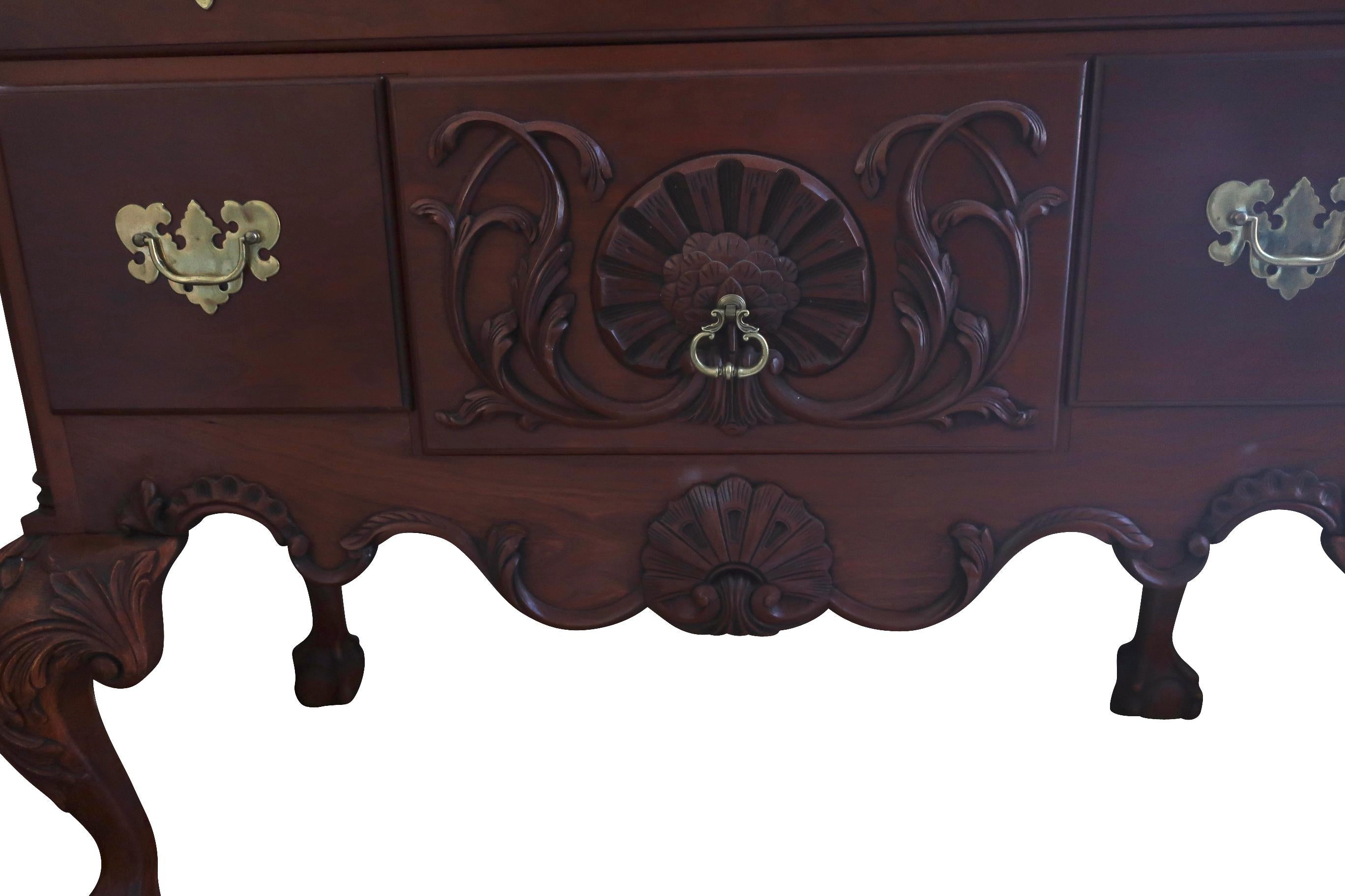 An Eldred Wheeler Philadelphia highboy with scroll top bonnet with flame and urn finials and carved rosettes. Nicely carved shell and streamers on the top bonnet. Scalloped aprons on cabriole legs with shells terminating in ball and claw feet. The