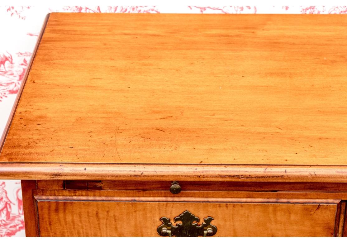 Eldred Wheeler tiger maple Chippendale style server presenting with a single long drawer below a pull out return and a pair of raised panel doors. The right side door with a brass snap closure at top. The whole is raised up on bracket feet. The