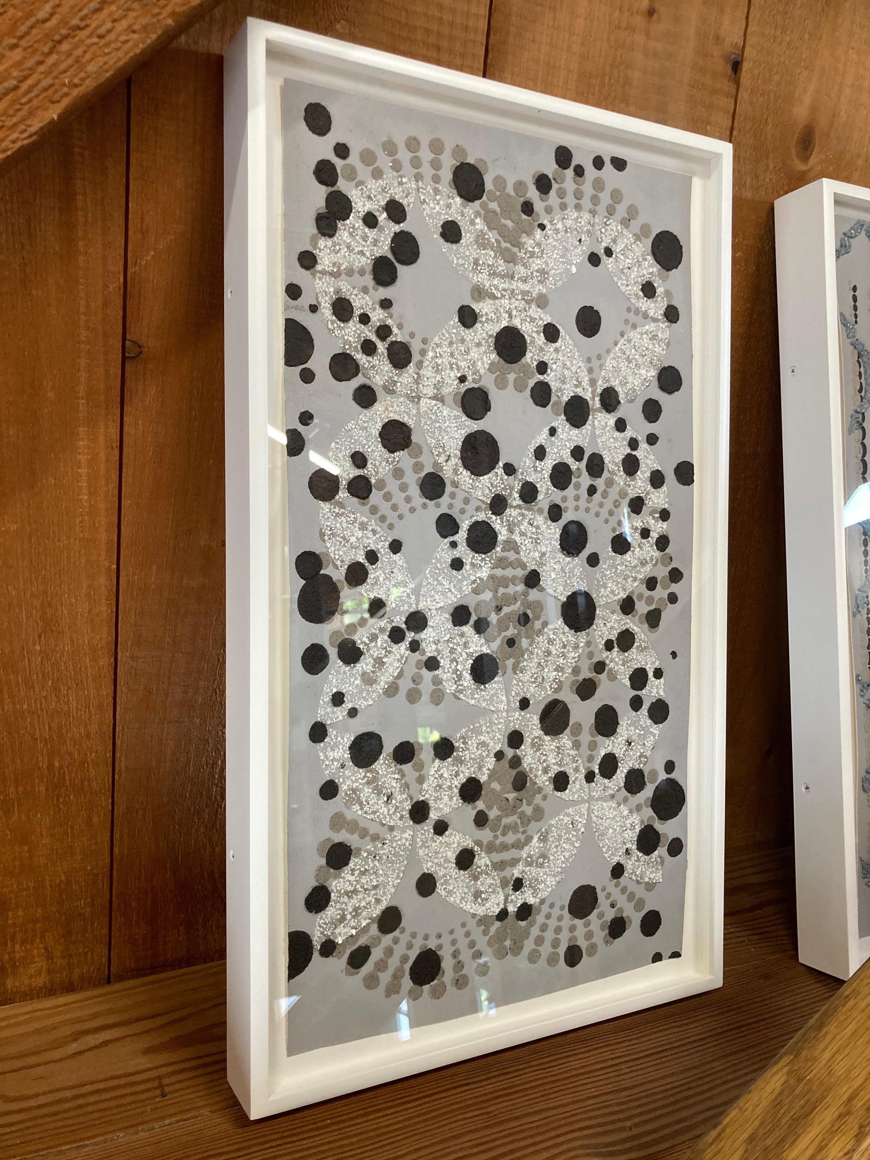 Nontraditional materials add texture to this vertical abstract work on paper by Eleanor White. Wood ash, eggshells and mica medium are carefully applied to gray painted paper creating meticulously ordered, radiating patterns of layered