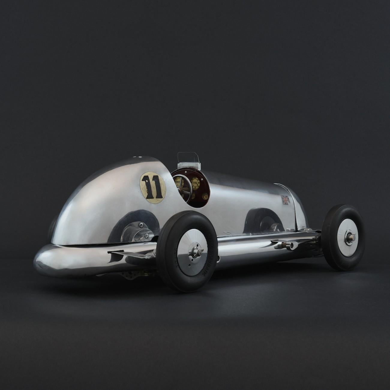The car comprises of a ‘Buck 2A’ chassis kit by Electra with hand made polished metal bodywork. A 6cc Stentor engine drives through a clutch providing power to a rear axle. Wheels and tyres are original ZN, which with the other components would date