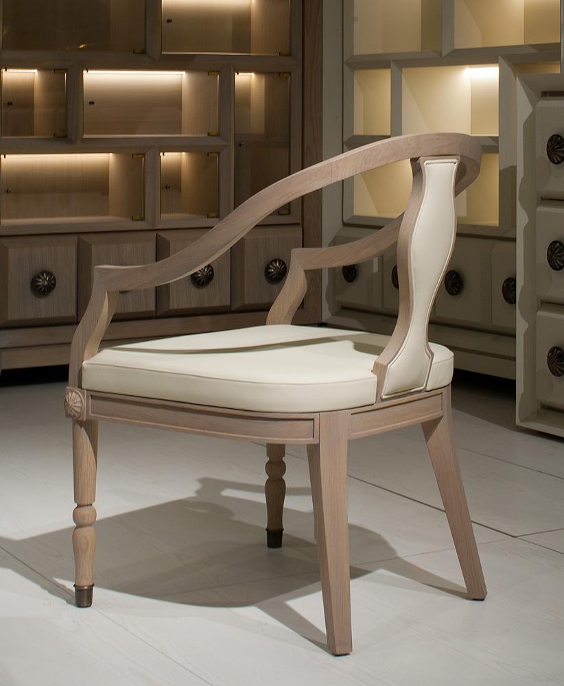 The Electress dining armchair, designed by Archer & Humphryes Architects of London, is entirely made of oak finished naturally. The shaped central part in the wooden back is covered with cream color Thema Leatherr, such as the seat. The turned front