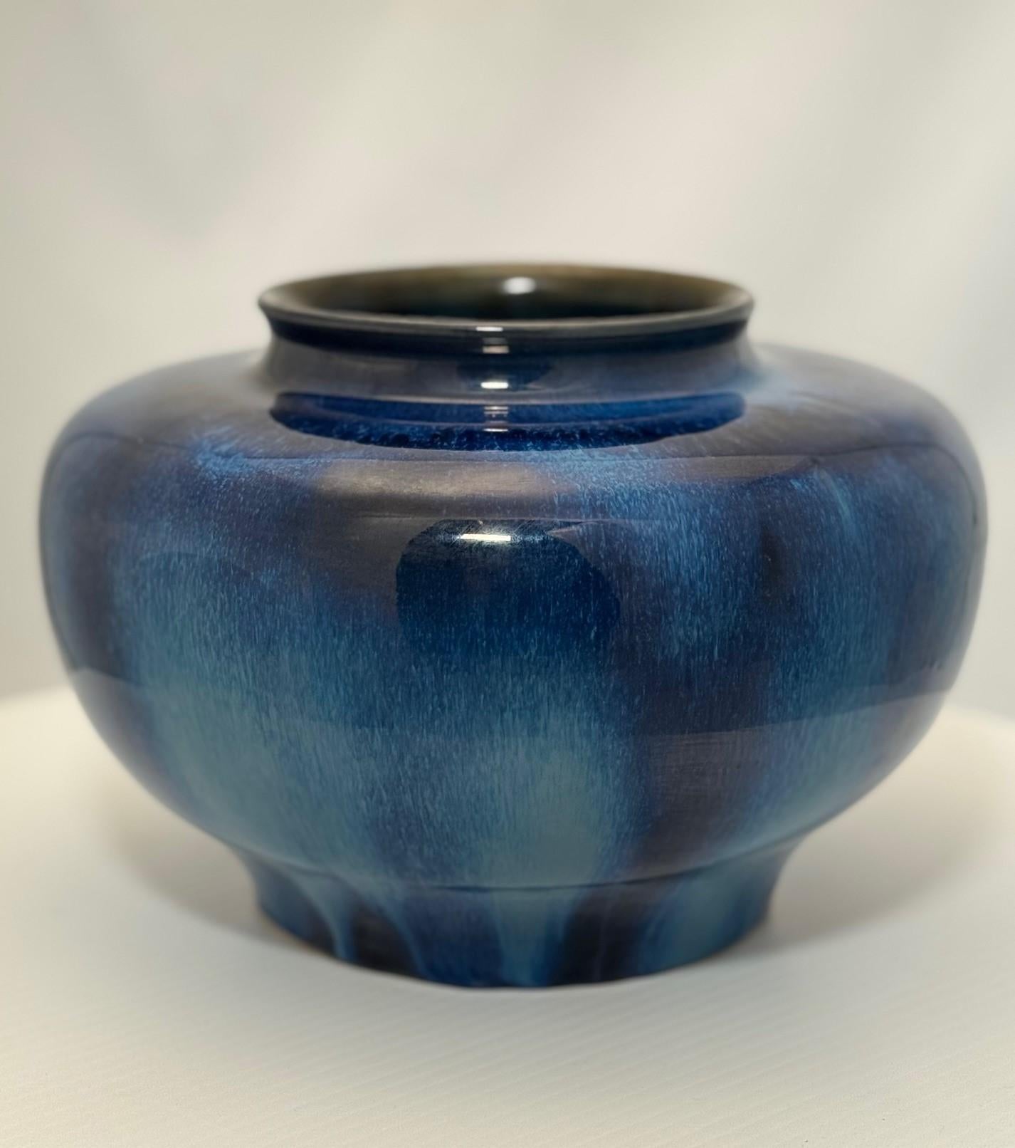 This subtle vase is of squat form and has  blue shaded lustre. It is stoneware and distinctly hefty but also delicately potted. Between the wars there was a great interest in firing and complicated glazes. 
