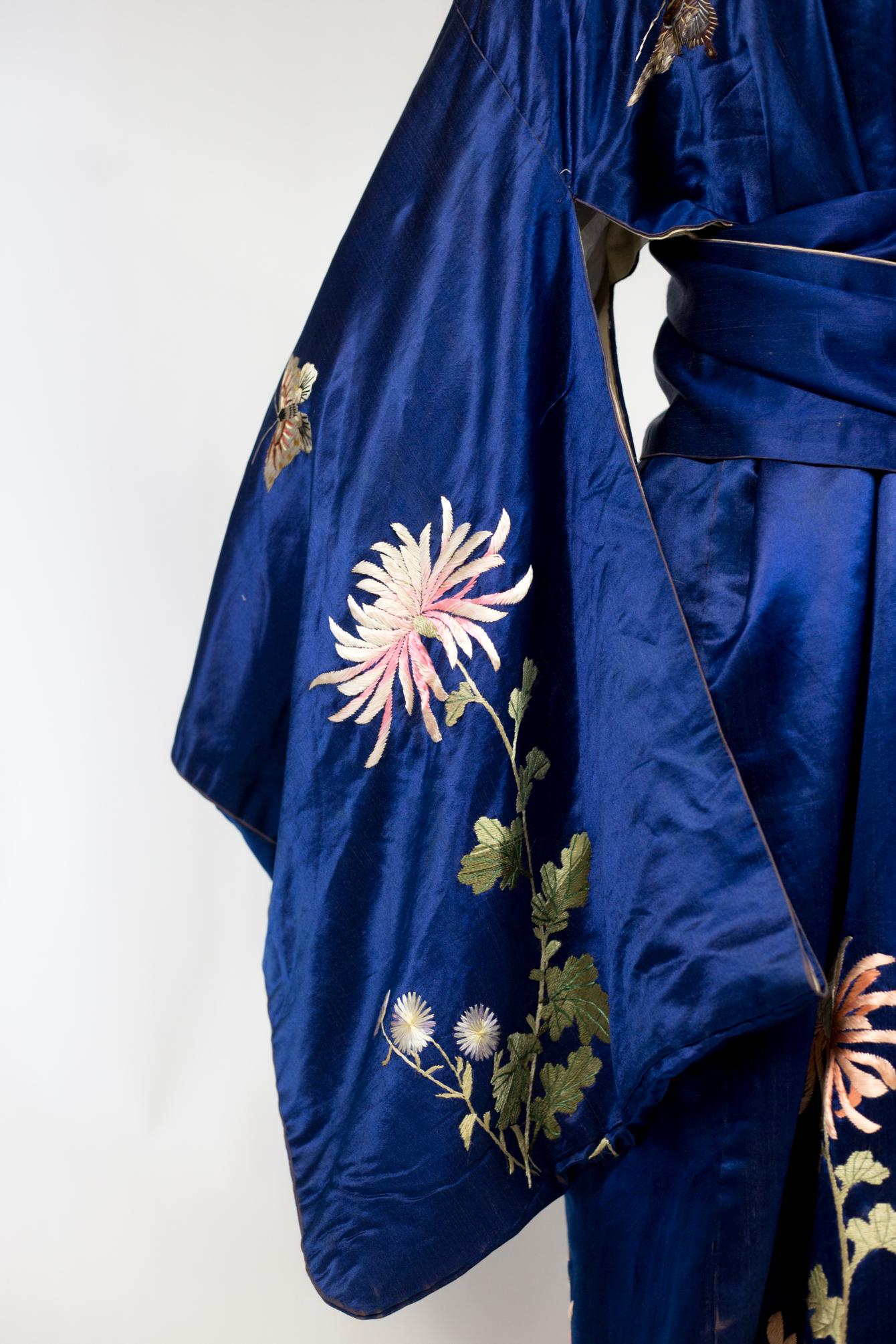 Circa 1920/1940

Japan

Beautiful Japanese party kimono in silk satin and embroidered electric blue soton. Beautiful embroidery with large chrysanthemum stems symbol of longevity, in a cameaieu of white, pink and pale green, dotted with large