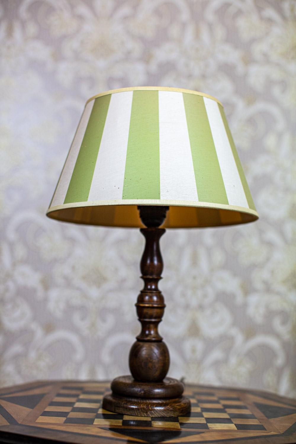 Electric Table Lamp From the Late 20th Century with Green-White Shade

We present you this electric table lamp from the 2nd half of the 20th century.
The base is wooden, whereas the cone-shaped shade is made of fabric.
The voltage is 230 V.
The lamp