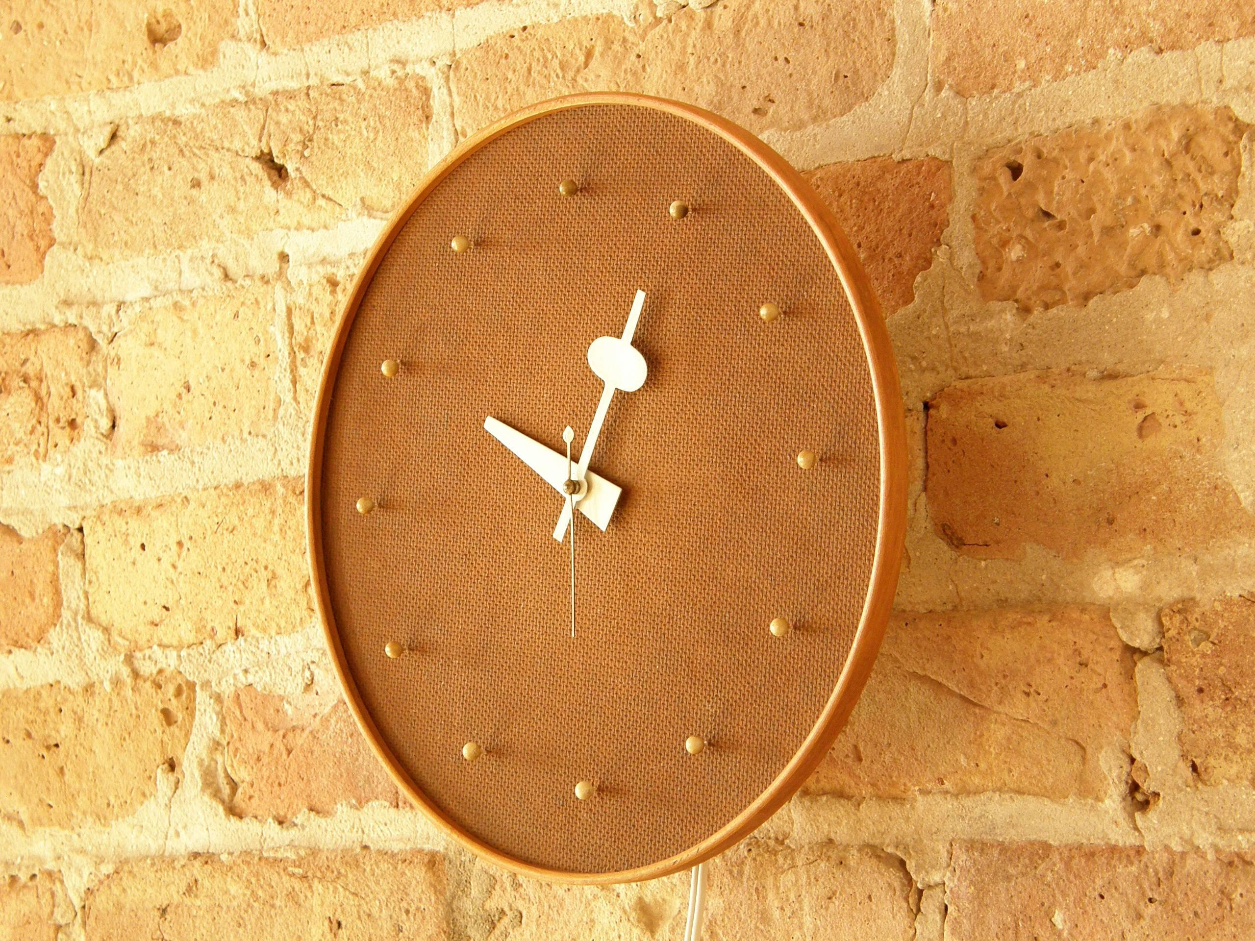 Electric wall clock designed circa 1950 by George Nelson Associates for Howard Miller with a masonite face, numbers resembling push pins, and a birch frame. 

 Please let us know if you have any questions.