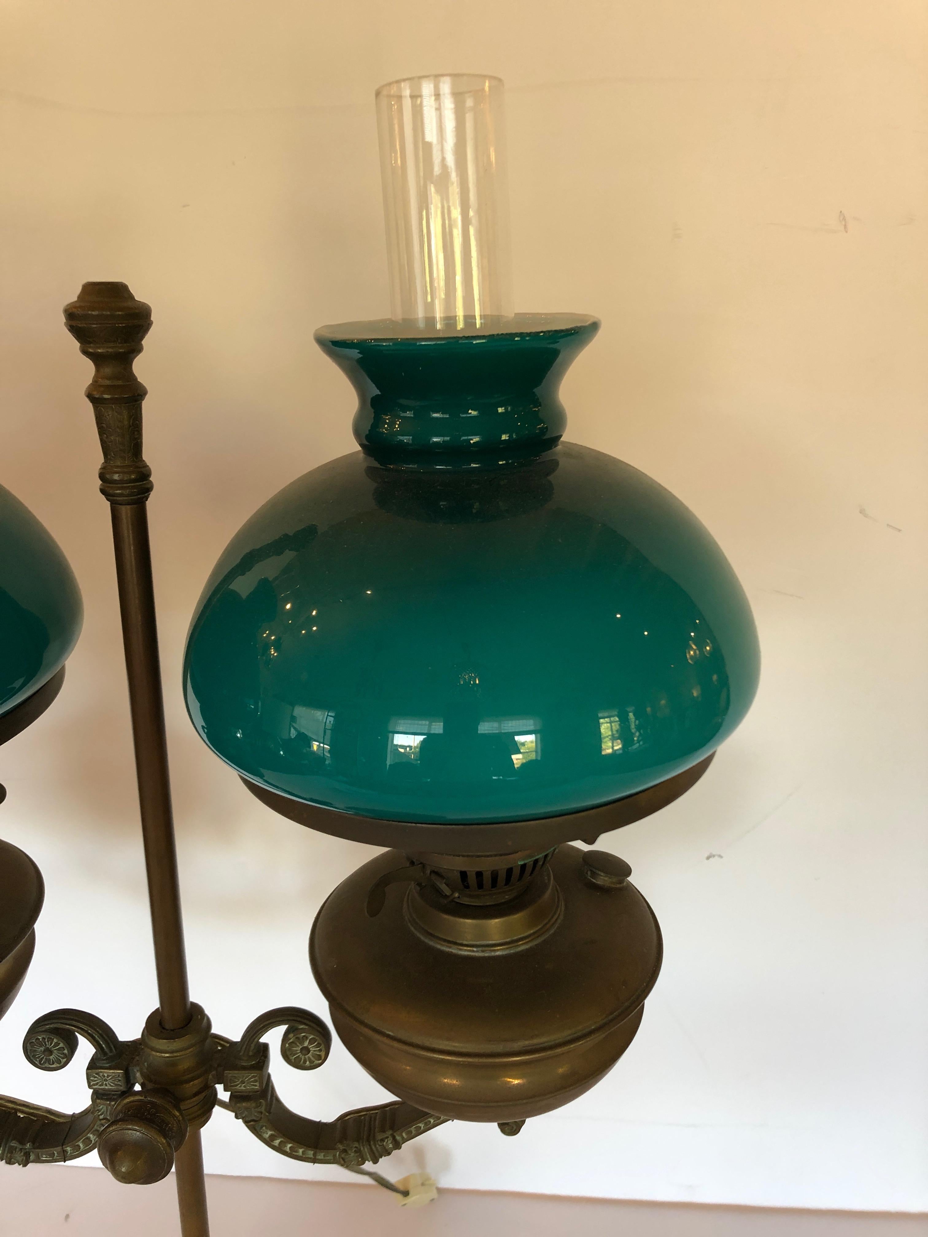 Une merveilleuse lampe de table ou de bureau antique en bronze qui était à l'origine une vieille lampe à huile ayant des abat-jour verts à double enveloppe. Câblé et prêt.