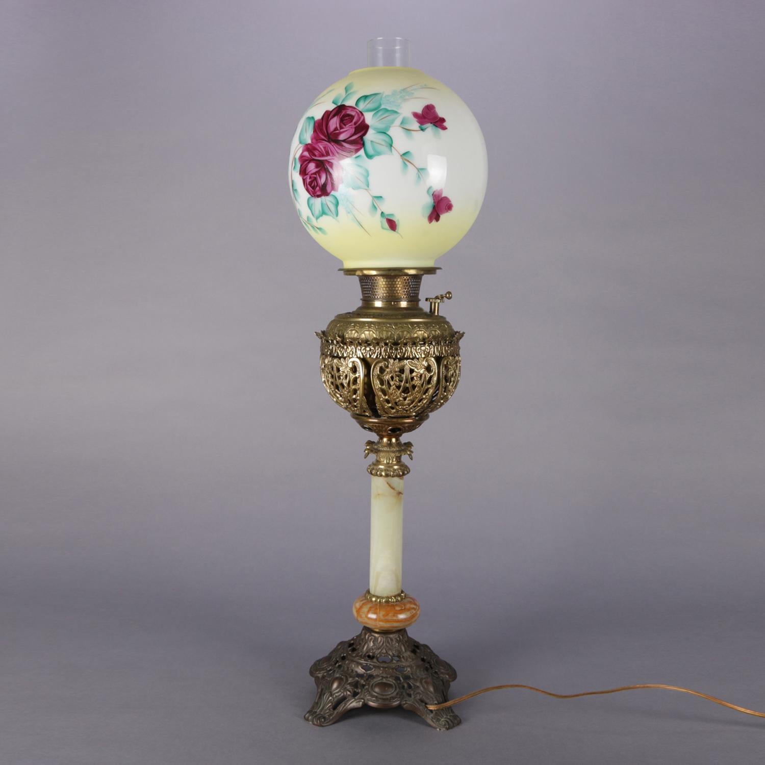 Antique electrified Gone-With-The-Wind table lamp features hand-painted globe with roses above pierce scroll and foliate brass font and raised on an onyx column seated on pierced and footed base, circa 1890.

Measures: 31