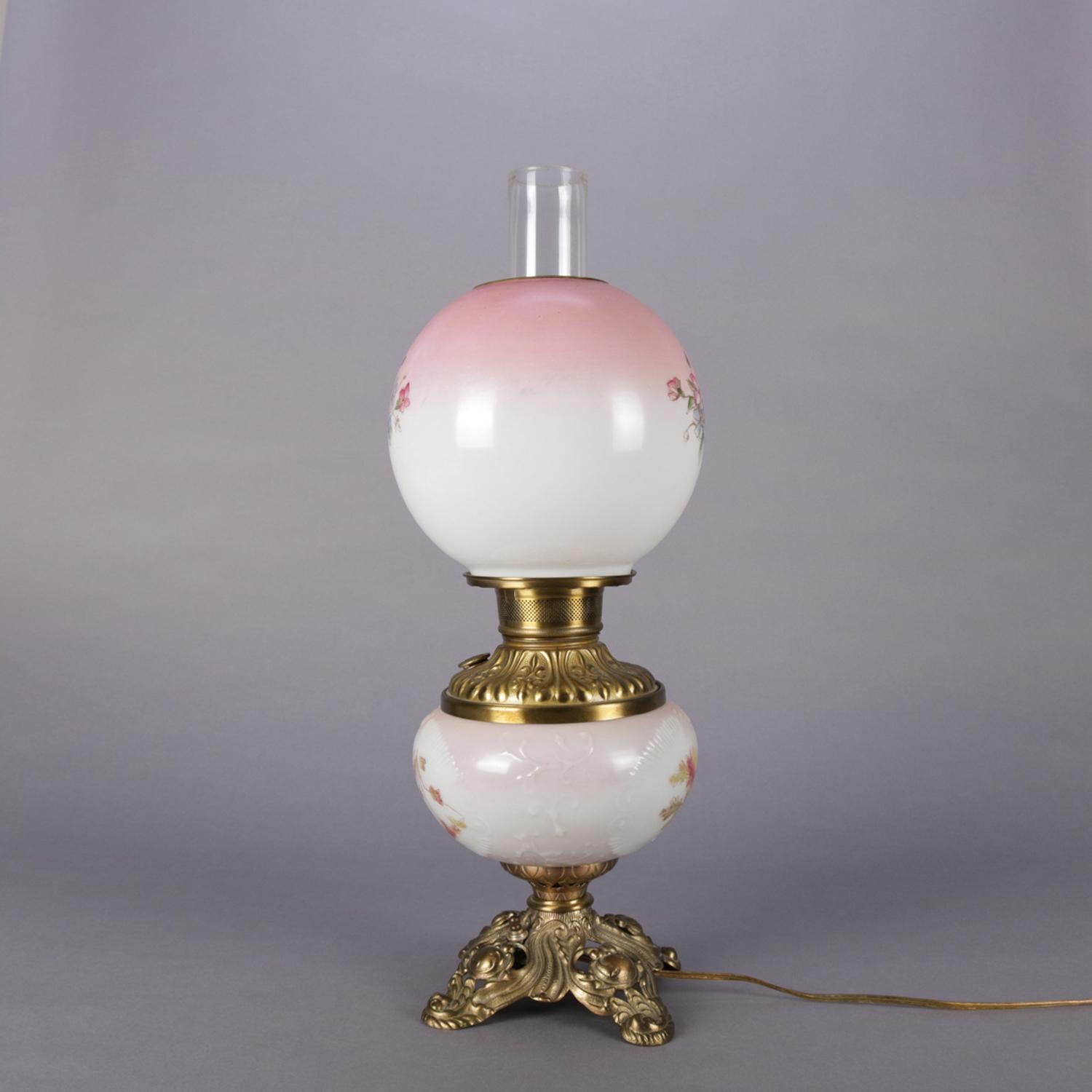 Antique electrified gone with the wind table lamp features hand-painted globe and font with floral spray roses raised on pierced and footed base, circa 1890.

Measures: 22