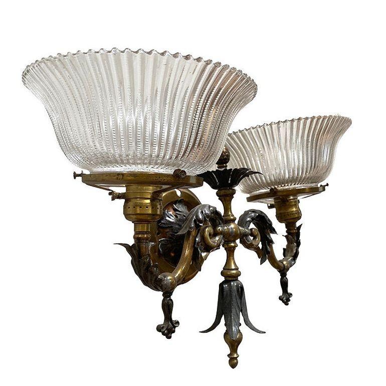 Una splendida coppia di doppie applique a gas in bronzo antico barocco/neoclassico, che mostra un'intricata lavorazione artigianale con fogliame ornamentale bicolore. Questi eleganti apparecchi da parete sono caratterizzati da dettagli ornamentali e