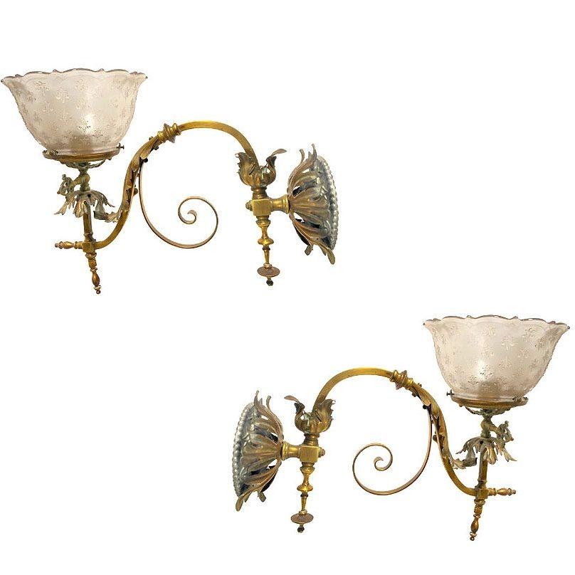 Rare pair of antique Brass Baroque/Neoclassical dual gas sconces, showcasing intricate craftsmanship with two-tone ornamental foliage throughout. These elegant wall fixtures feature ornate detailing and a rich patina, bringing back the end of the