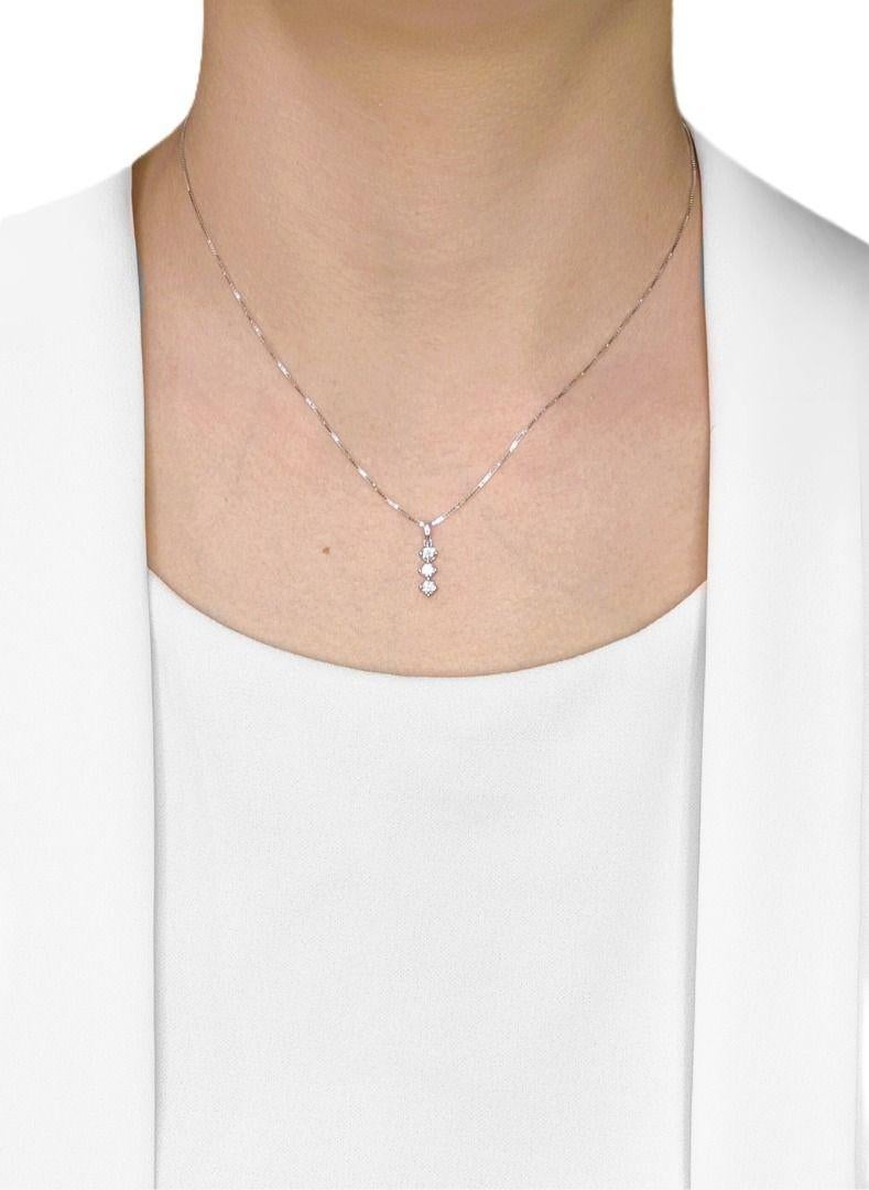 Découvrez une élégance durable avec ce pendentif intemporel à trois pierres de Gold Heart, méticuleusement réalisé en or blanc 18 carats rayonnant. Trois éblouissants diamants ronds naturels de taille brillante, totalisant 0,27 carat, sont