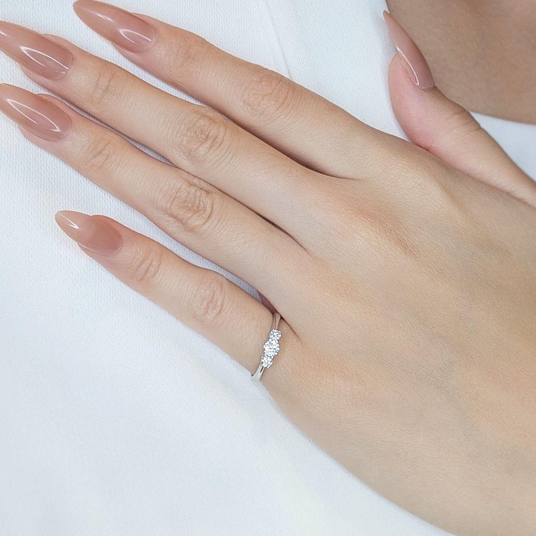 Zelebrieren Sie zeitlose Schönheit mit diesem eleganten 0,29-karätigen Dreistein-Diamantring, einem Symbol für Liebe, Engagement und Brillanz. Dieses exquisite Schmuckstück aus leuchtendem 18-karätigem Weißgold ist mit drei natürlichen runden