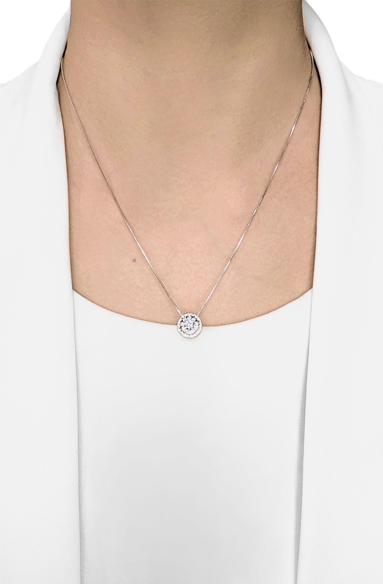 Symbole rayonnant d'élégance et d'éclat, ce collier en or blanc 14 carats présente en son centre un éblouissant diamant naturel rond taillé en brillant (0,23 ct, G-H/VS), entouré d'un double halo lumineux de 25 diamants d'accentuation totalisant
