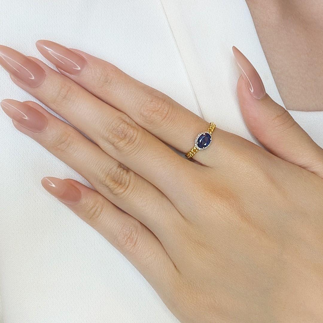 Dieser atemberaubende Ring aus exquisitem 18-karätigem Gelbgold strahlt zeitlose Eleganz und Raffinesse aus. Im Mittelpunkt steht ein blauer Saphir im Ovalschliff mit einem Gewicht von 0,6 Karat, der einen tiefen, bezaubernden Charme ausstrahlt. Um